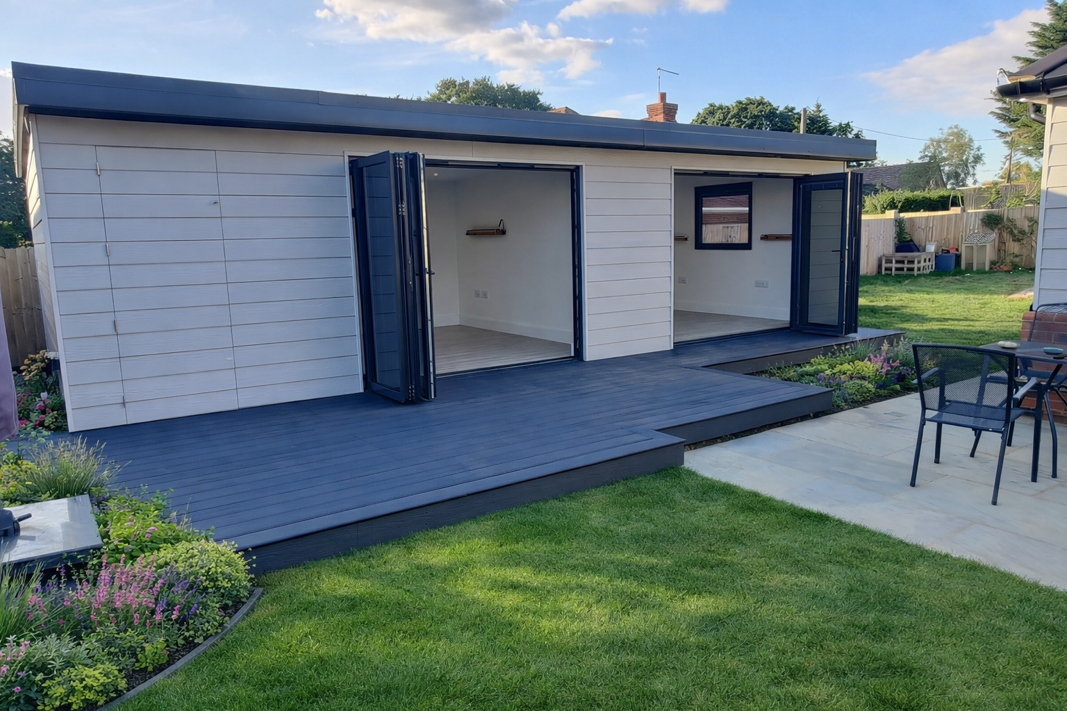 White garden room with bifold doors and composite decking