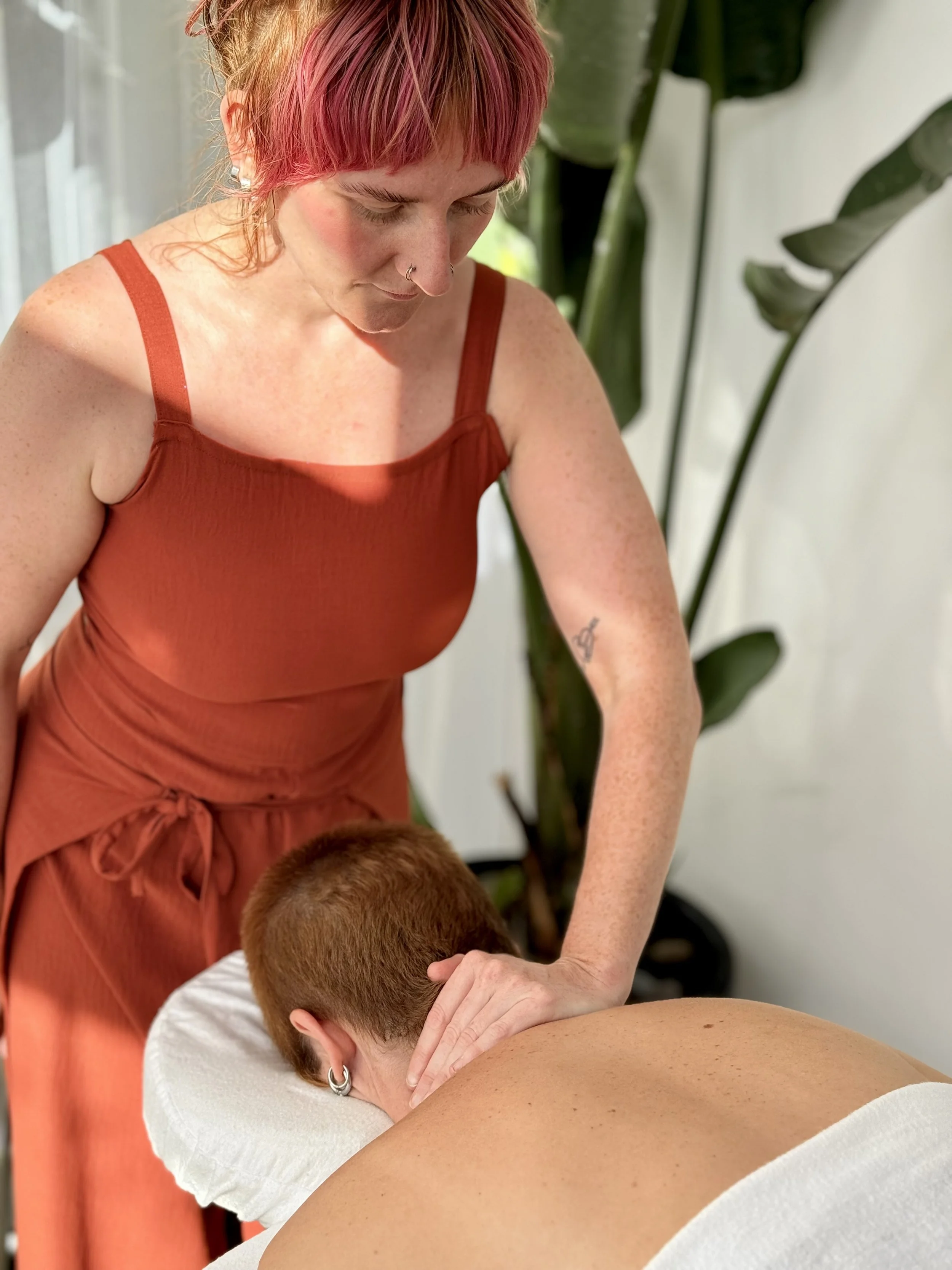 a somatic therapist is working on someone lying on a bed