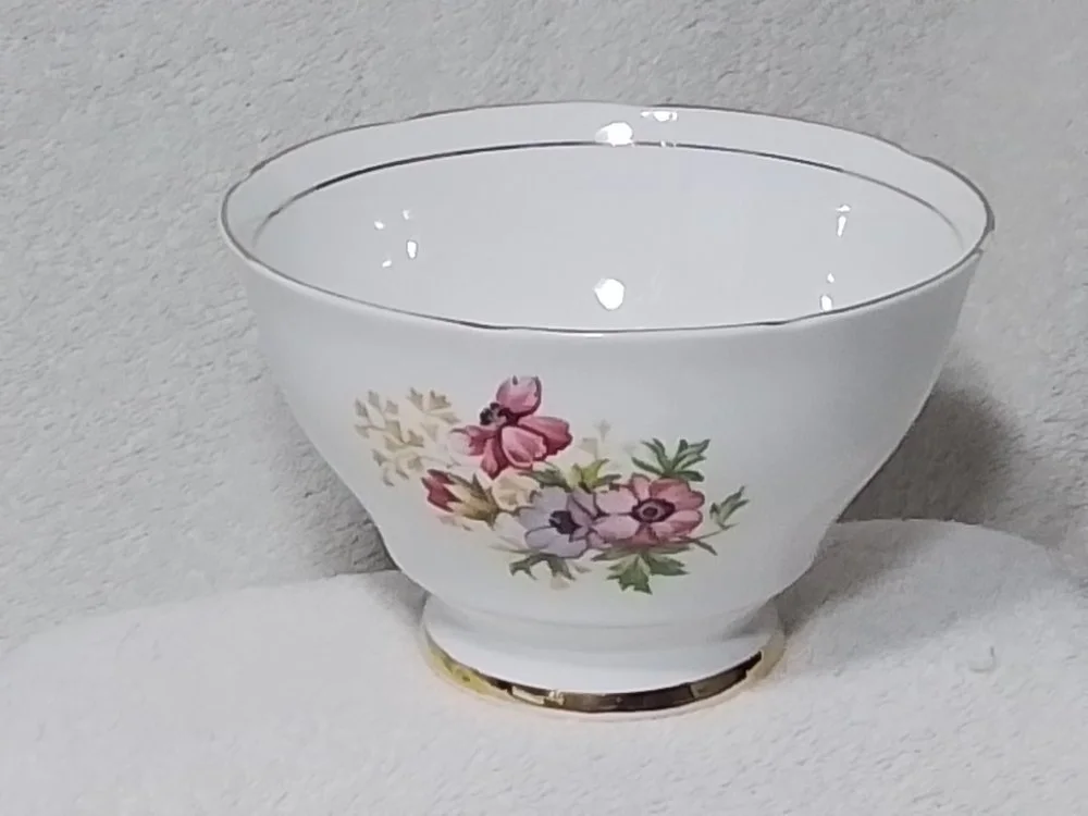 White decorative bowl with floral pattern on a soft surface.