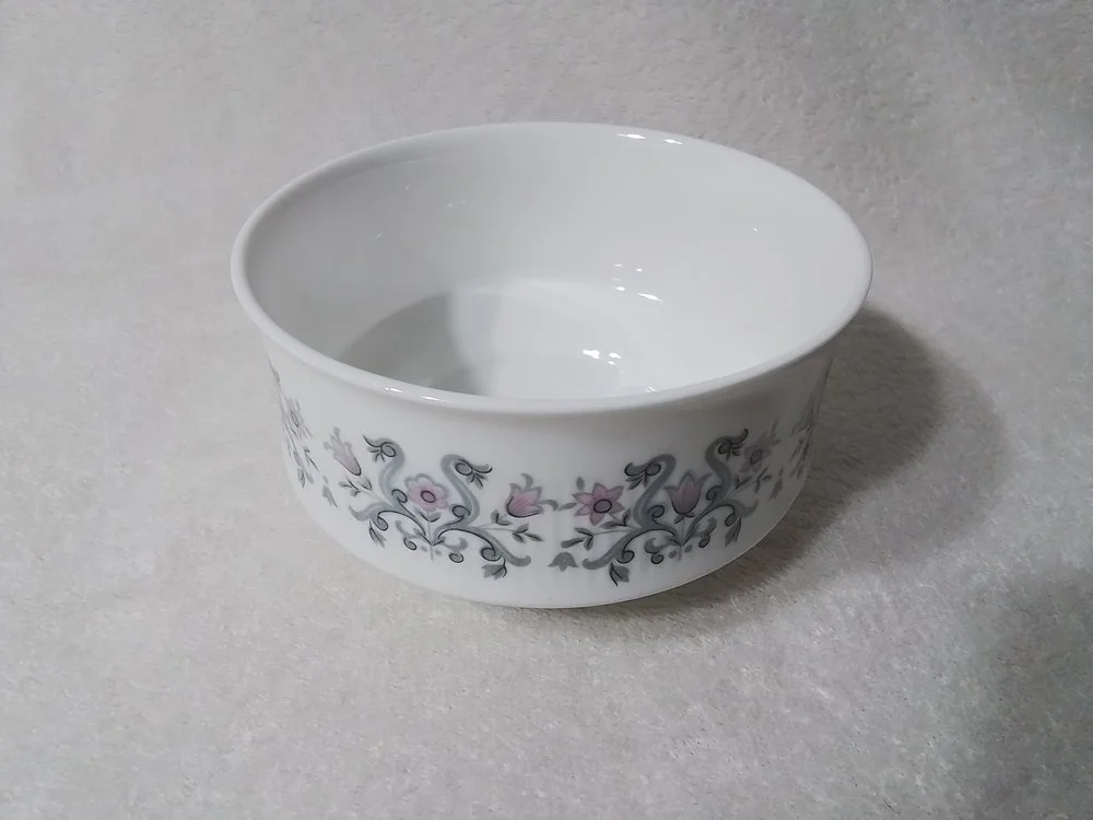 White porcelain bowl with floral pattern on a grey surface.