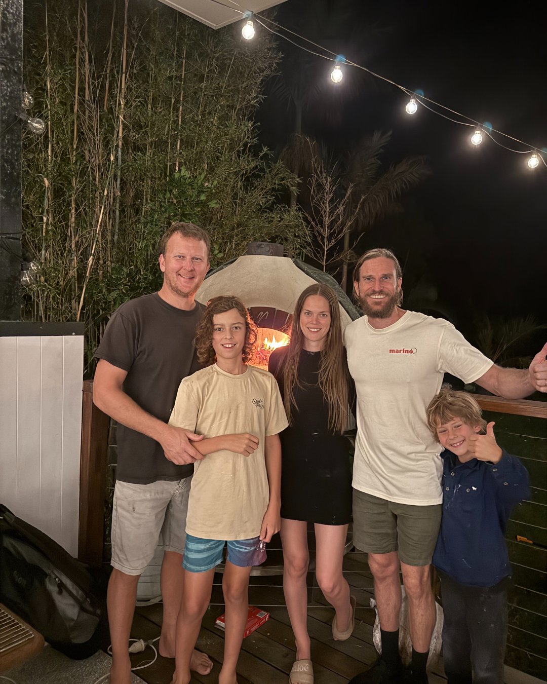 Private pizza masterclass at home on the Gold Coast with Luke Marino and guests gathered around a wood fired oven at night.