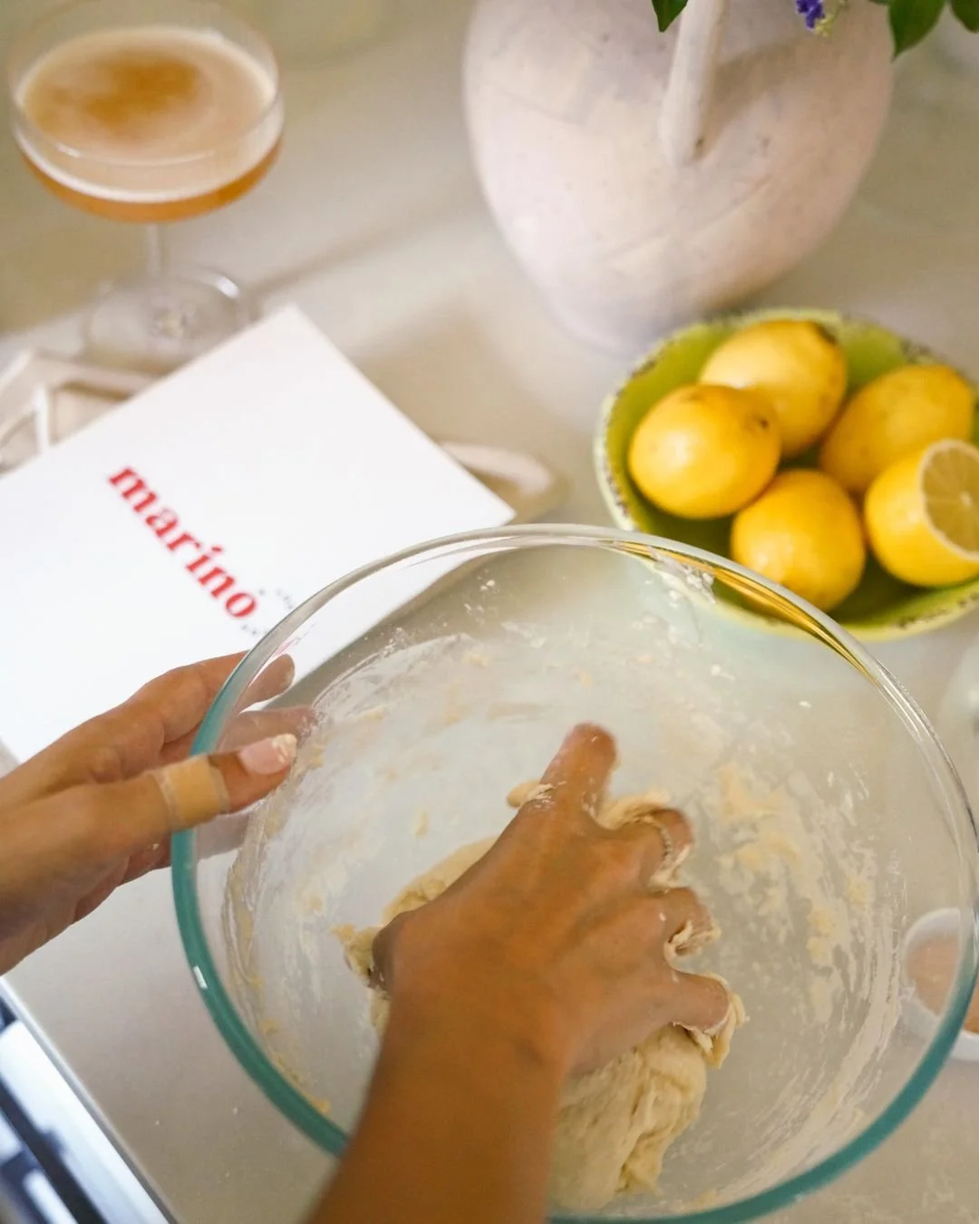 Close up of hands kneading pizza dough in a glass bowl during a Marino & The Dough 72 hour fermentation masterclass at home