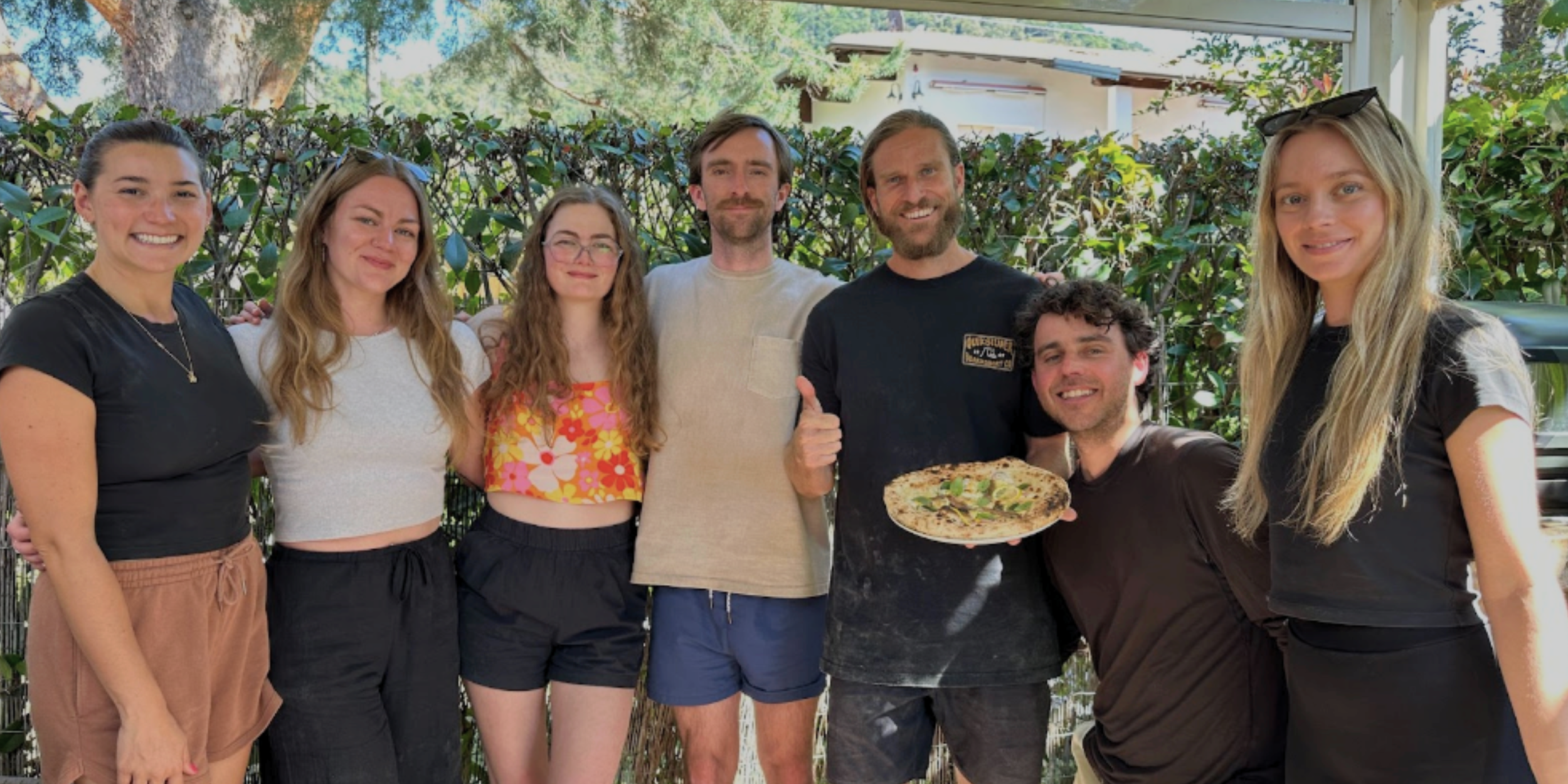 Group photo from a Marino & The Dough private pizza masterclass holding freshly made pizza on the Gold Coast