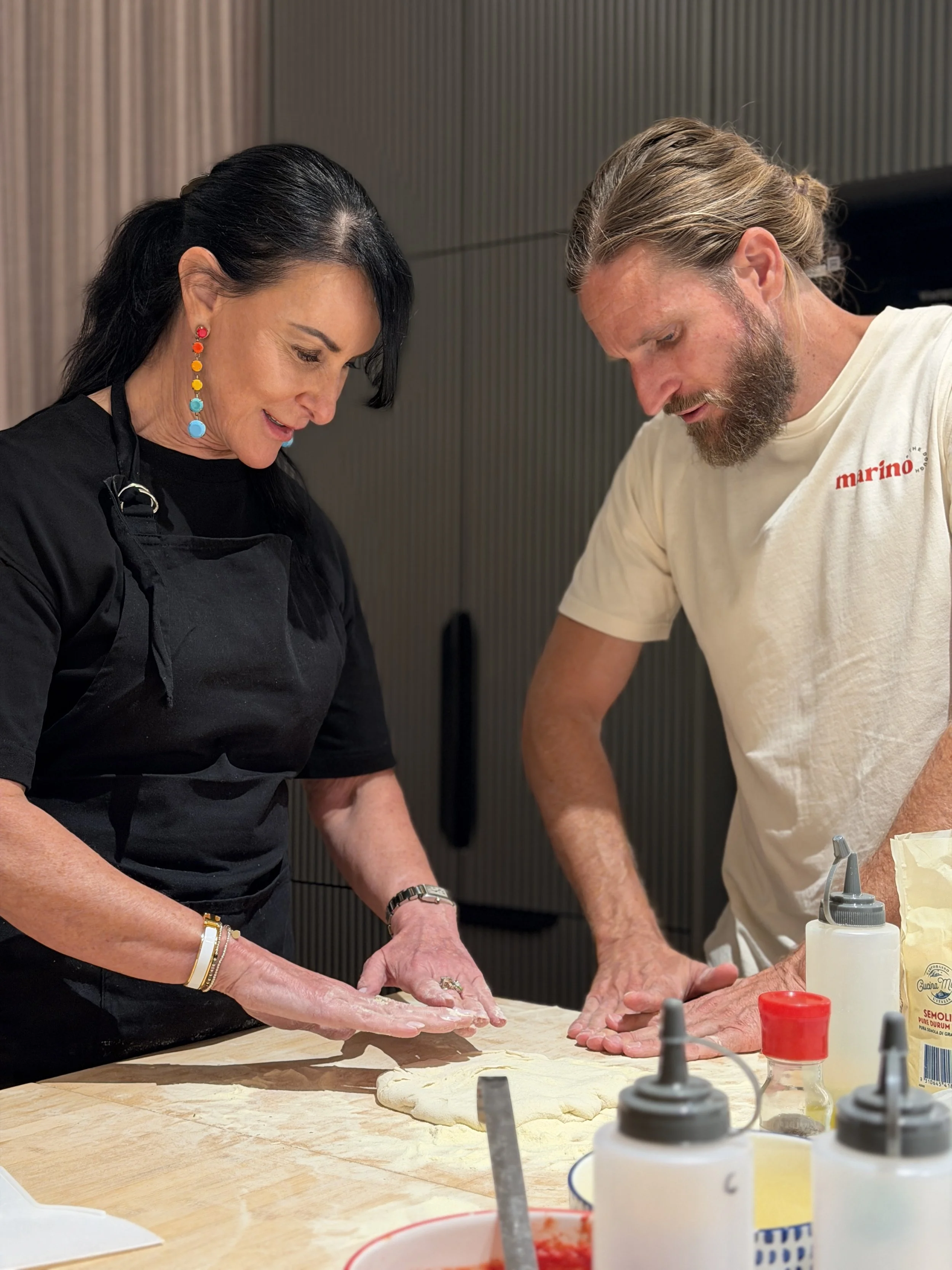 Luke Marino guides a guest through shaping pizza dough