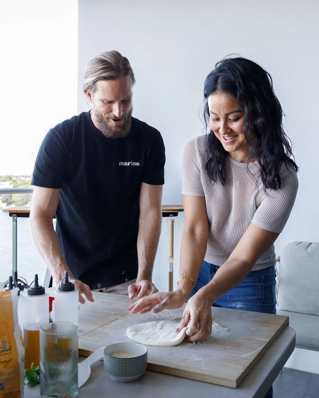A guest shaping pizza dough by hand while Dough Artisan Luke Marino offers guidance in a home kitchen masterclass.