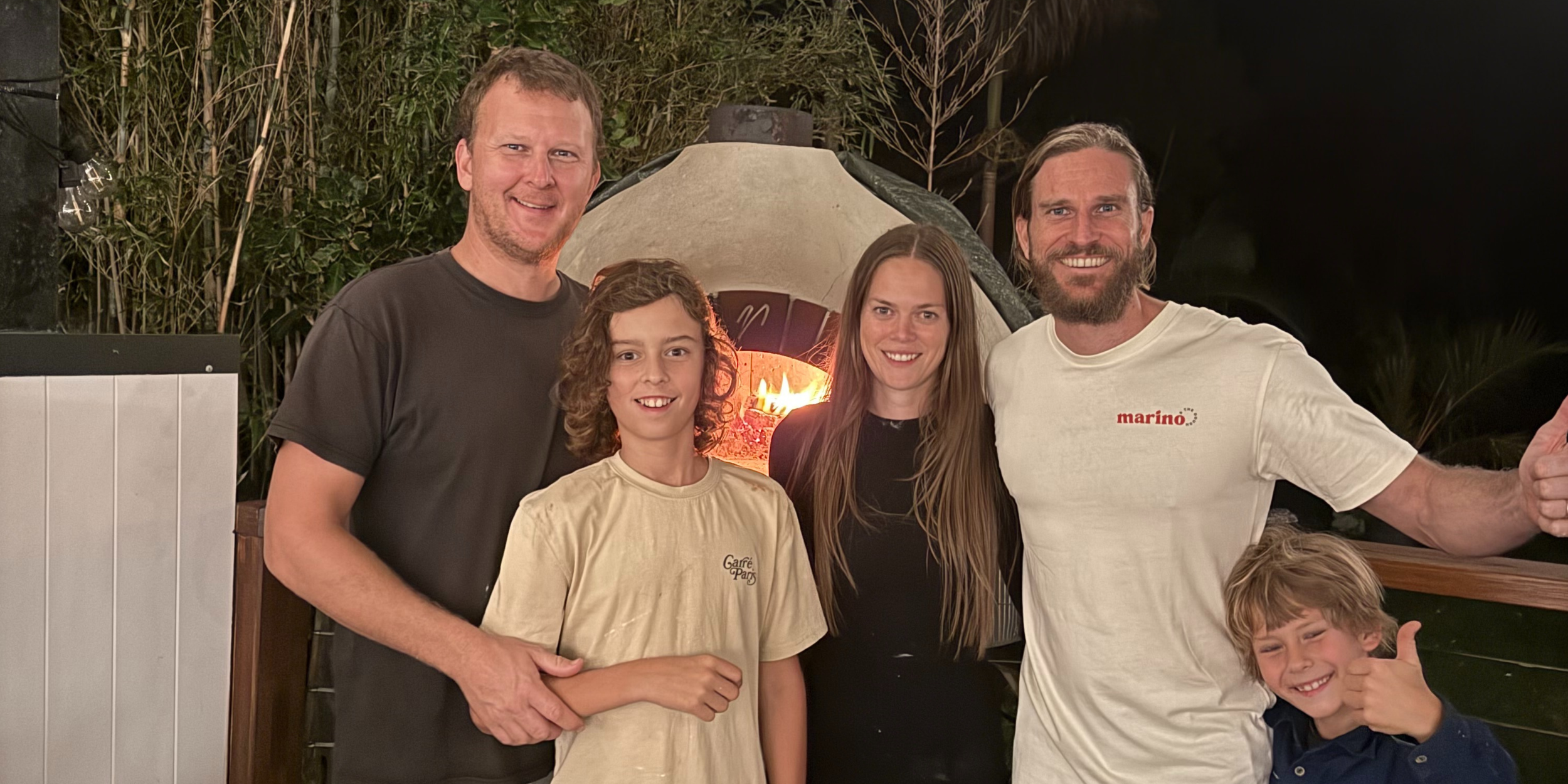 Luke Marino with guests at a Marino & The Dough private pizza masterclass beside a wood fired pizza oven on the Gold Coast