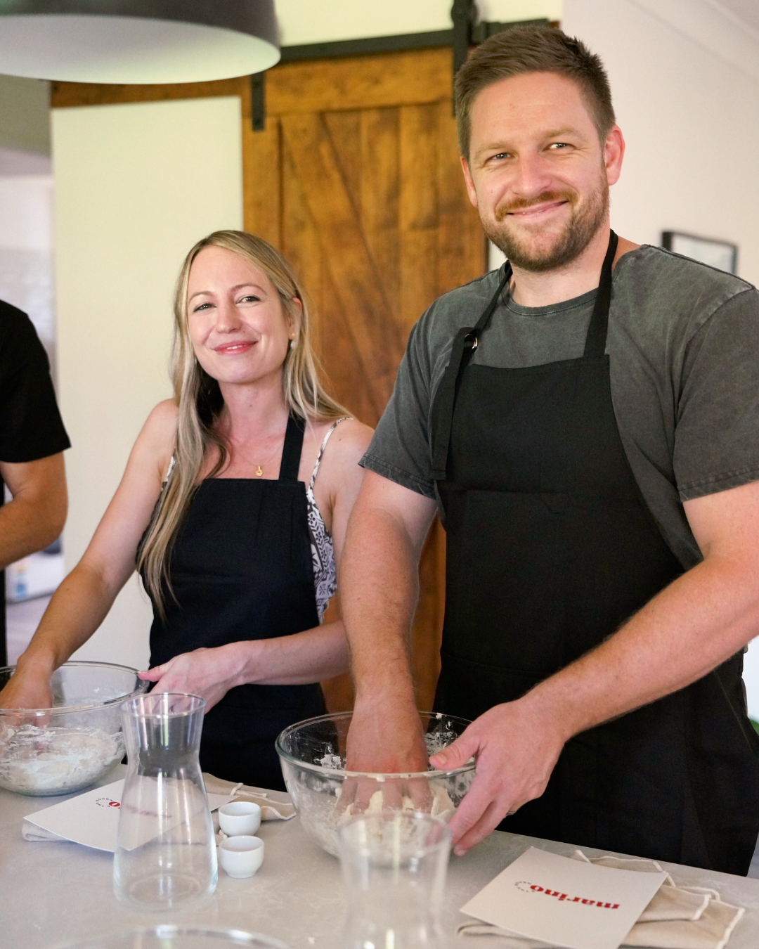 Couple learning to make pizza in a hands on masterclass with dough mixing and relaxed home setup