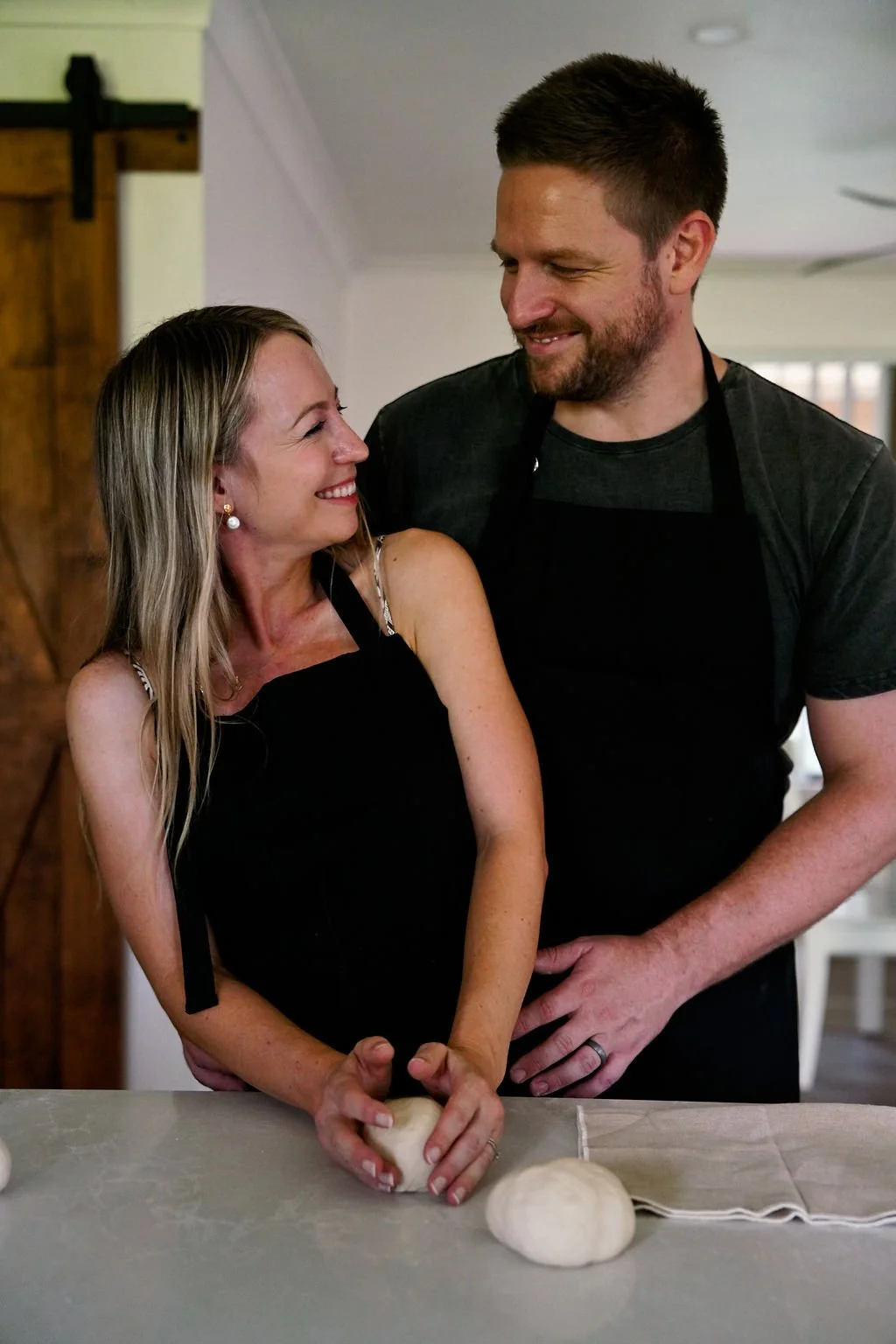 Couple enjoying a private pizza masterclass at home on the Gold Coast, shaping fresh dough together during a hands-on cooking experience.