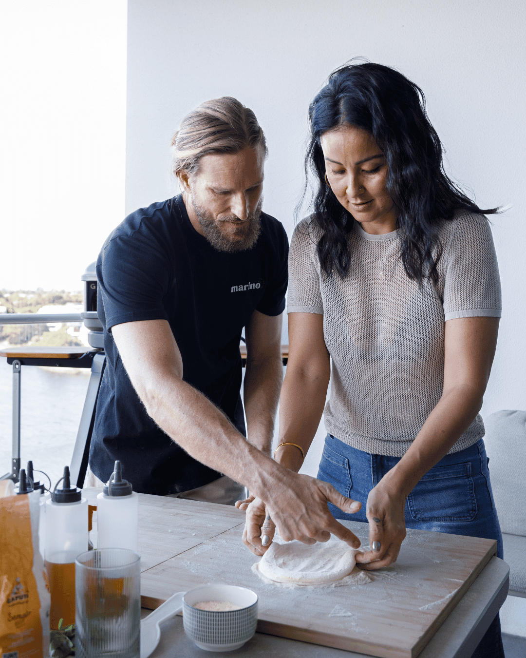 A guest mixing pizza dough in a glass bowl while Dough Artisan Luke Marino guides the process during a private masterclass.