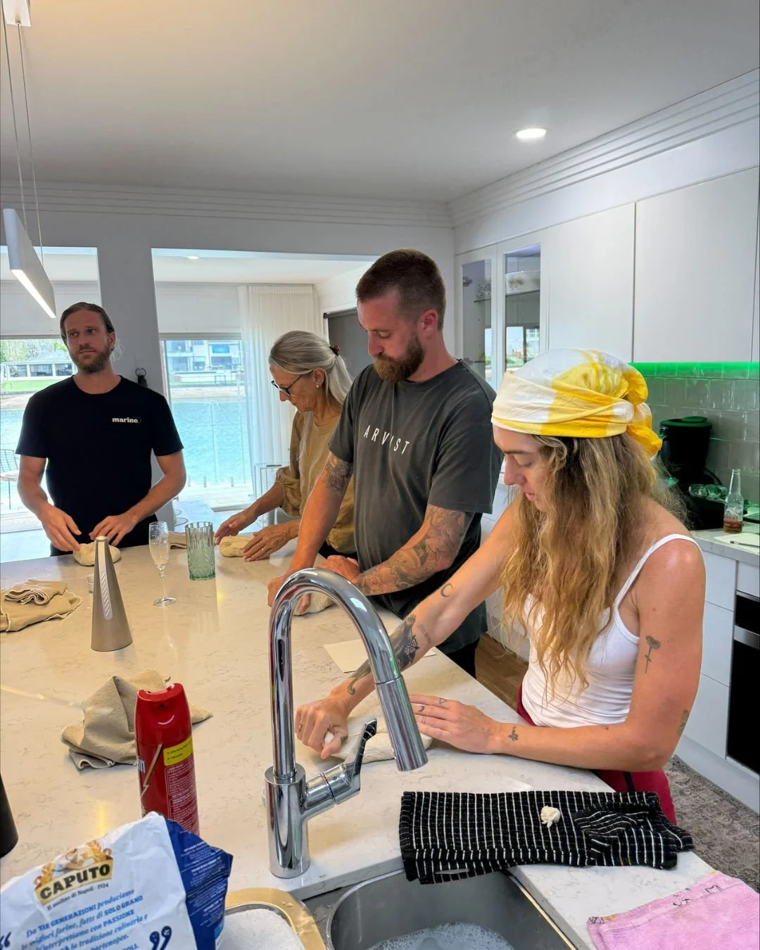Guests shaping pizza dough at a kitchen island during a hands on Marino & The Dough masterclass using 72 hour fermented dough
