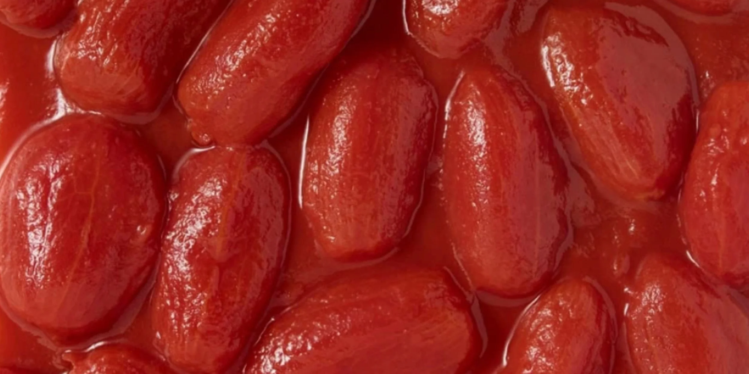 A close-up of glossy whole peeled San Marzano tomatoes in rich tomato juice — the vibrant base for Marino & The Dough’s signature pizza sauce.