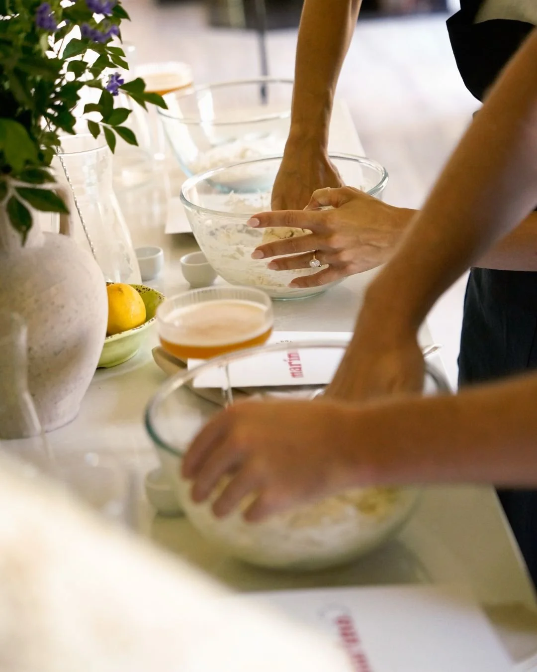 Guests preparing and mixing pizza dough in glass bowls during a private Marino & The Dough masterclass at home with premium ingredients and 72 hour fermented dough