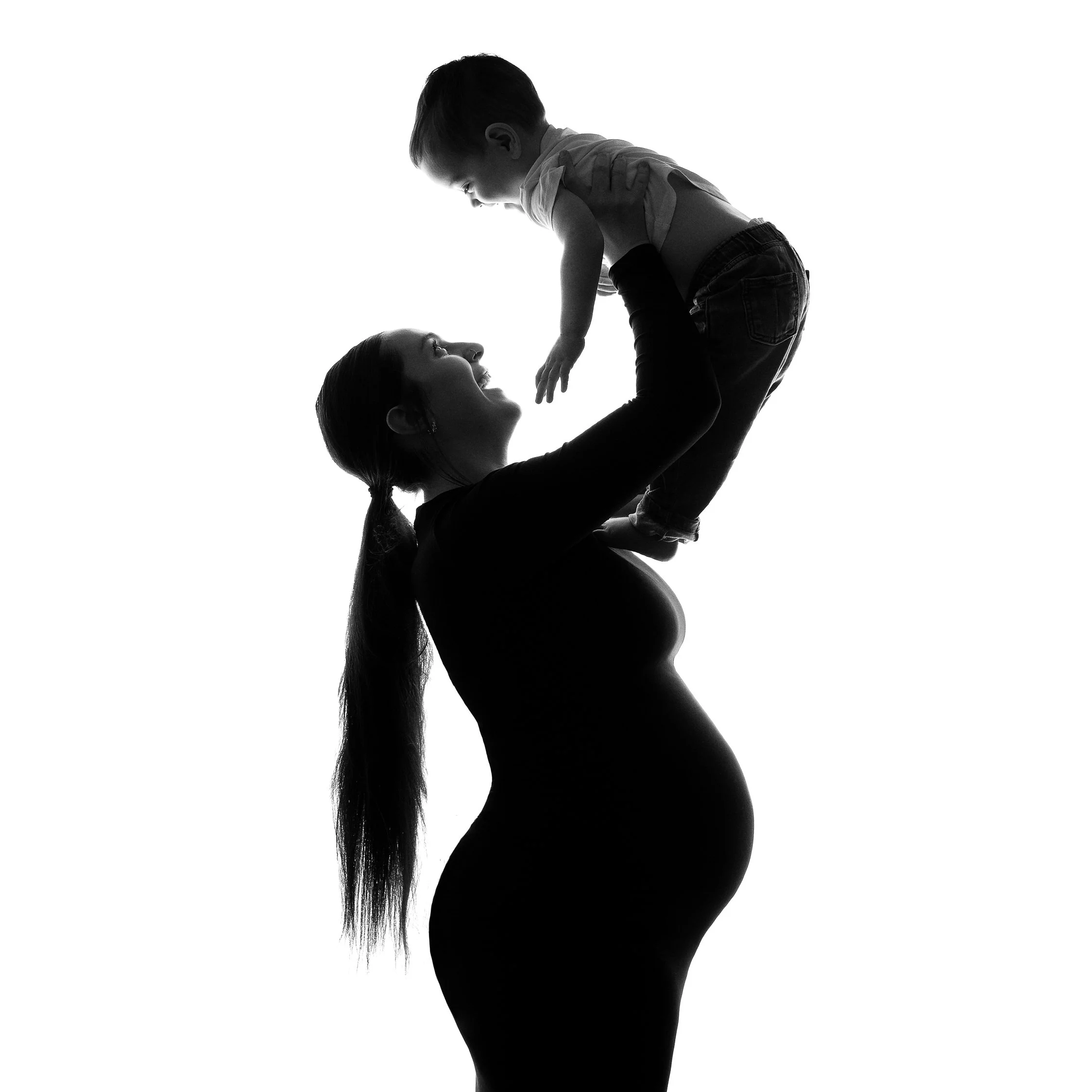 Pregnant-Mum-lifting-up-her-older-child-fun-maternity-photoshoot