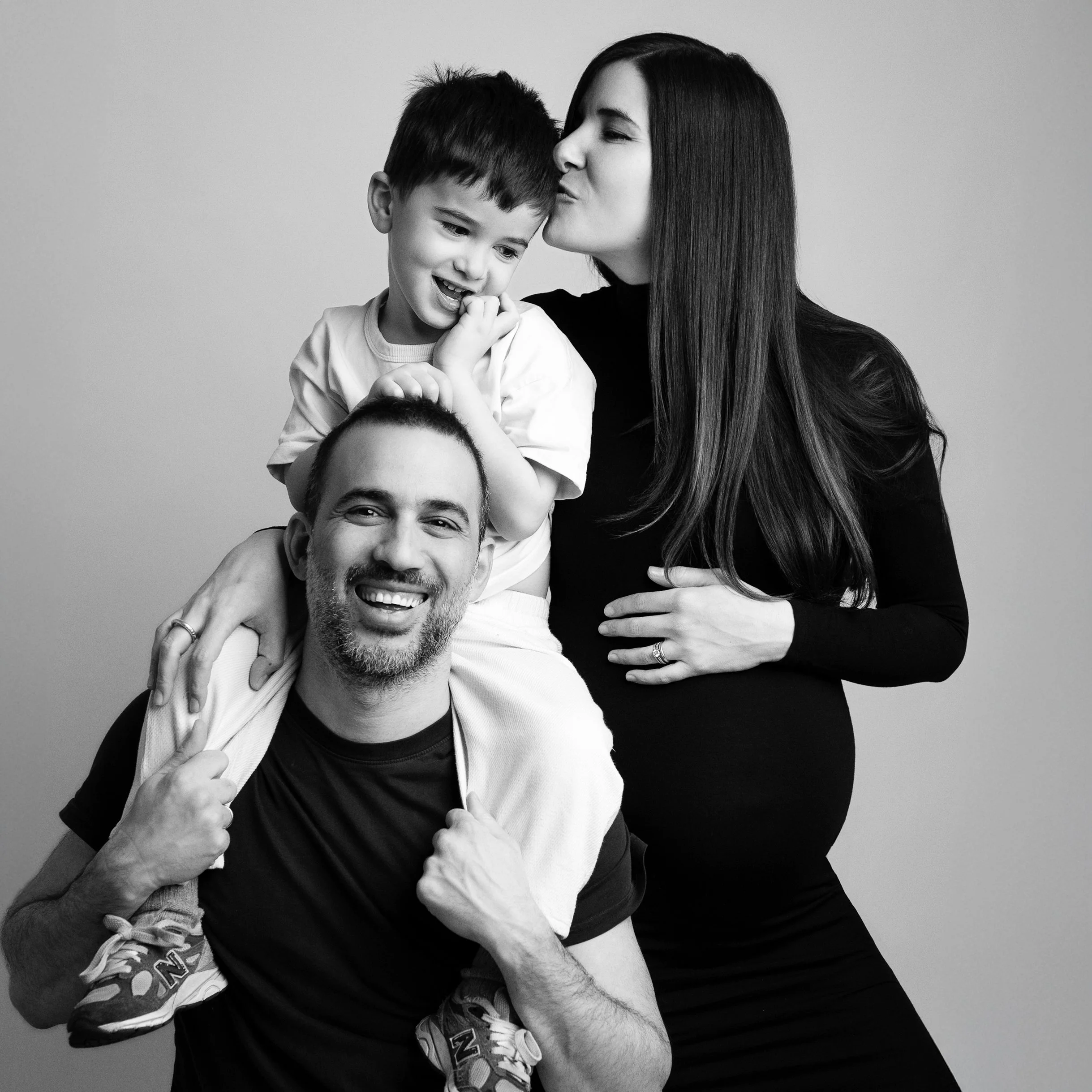 fun maternity pose of a mum and dad with their older son - Barnet Maternity Photographer