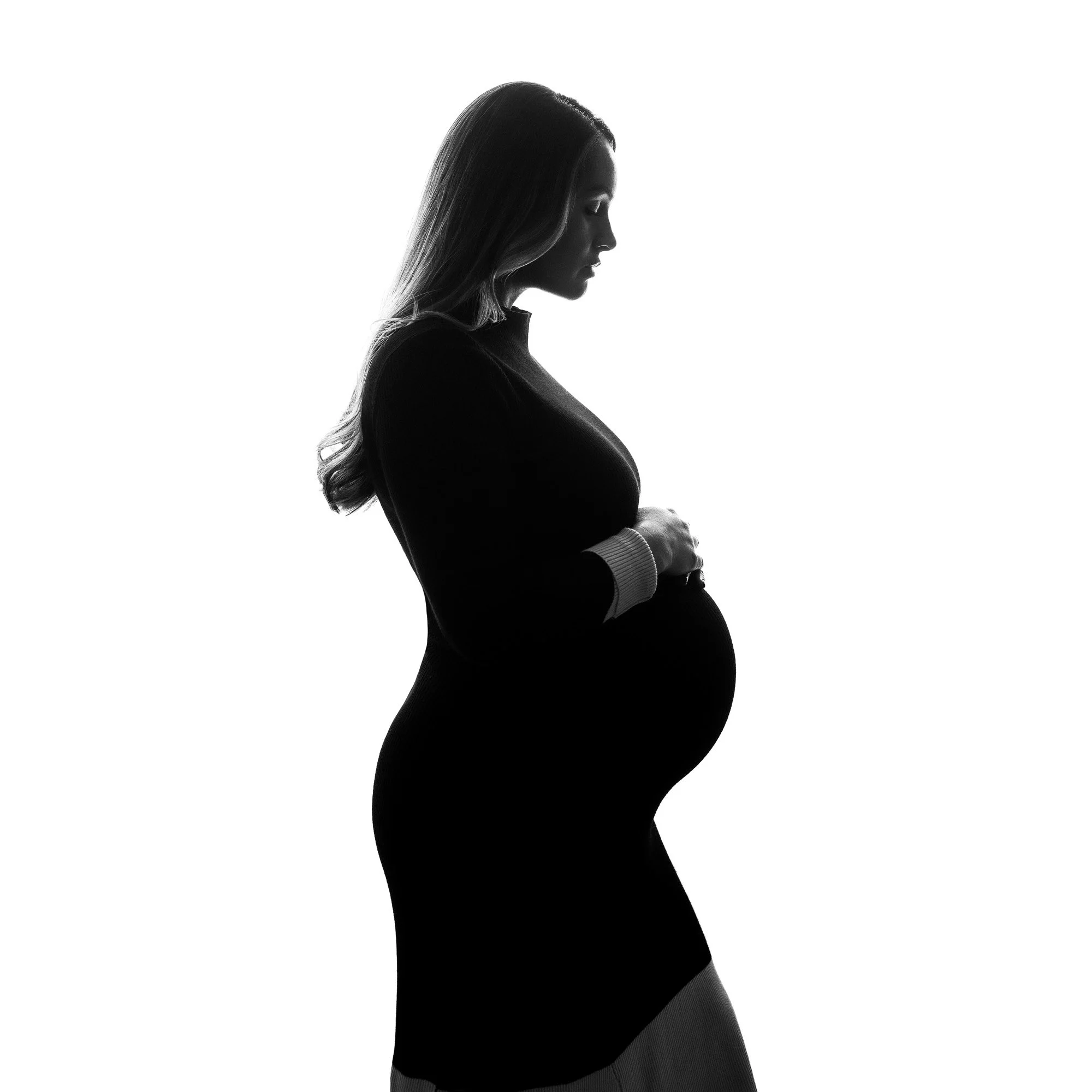 Black and white silhouette of a pregnant woman in profile, gently holding her belly, against a white background.
