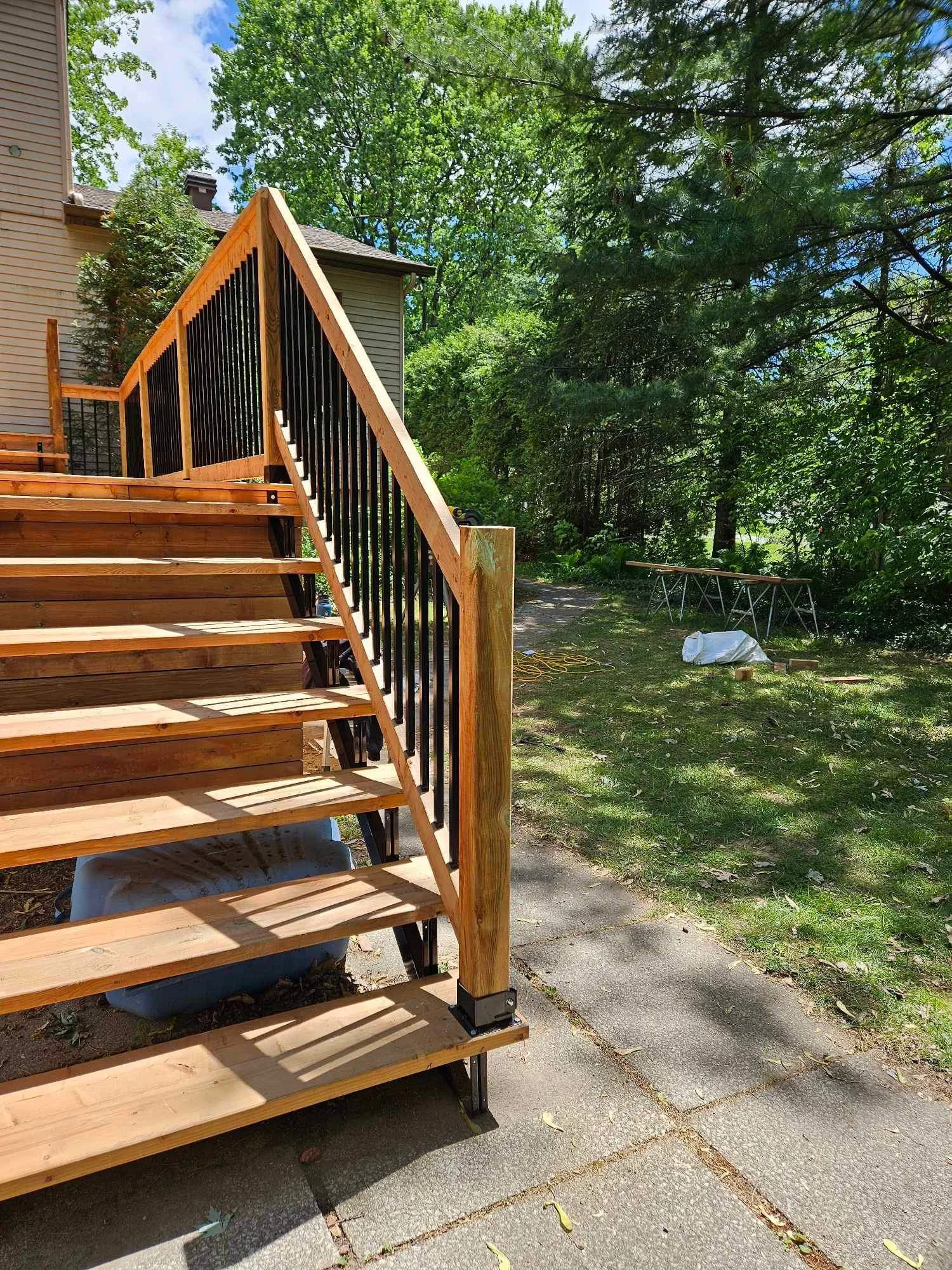 Escalier en bois avec rambarde en métal noir.