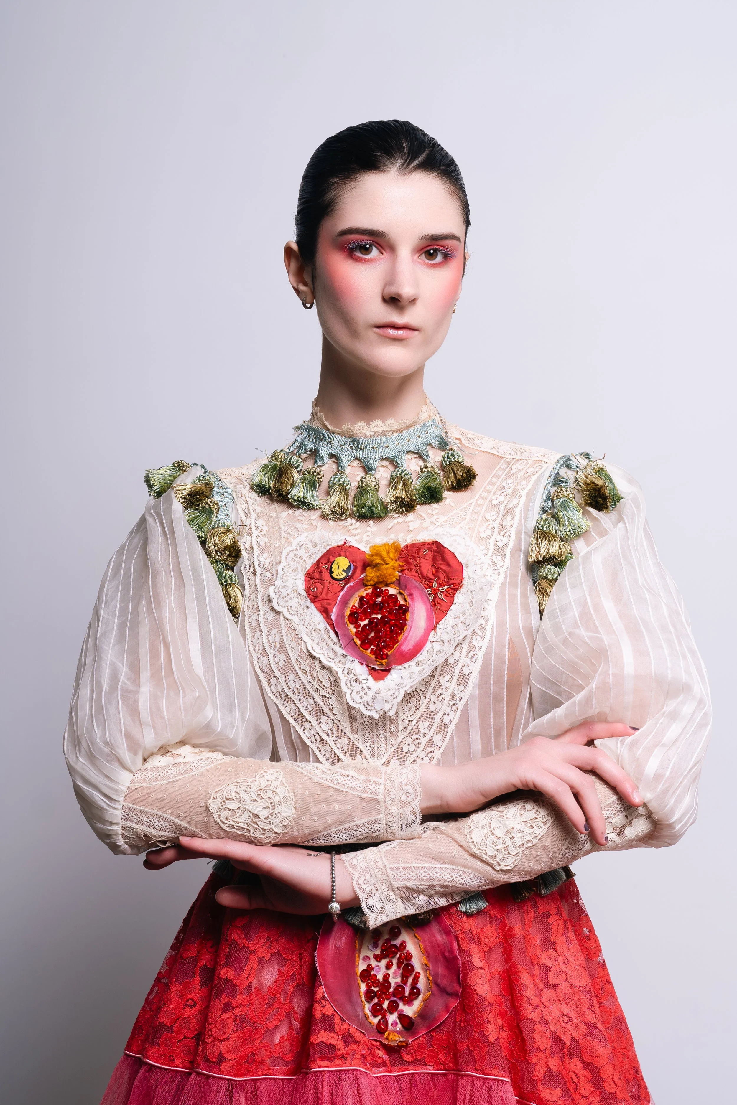 Portrait of a woman in an ornate vintage dress with pomegranate heart embroidery, blending fashion and artistic expression.