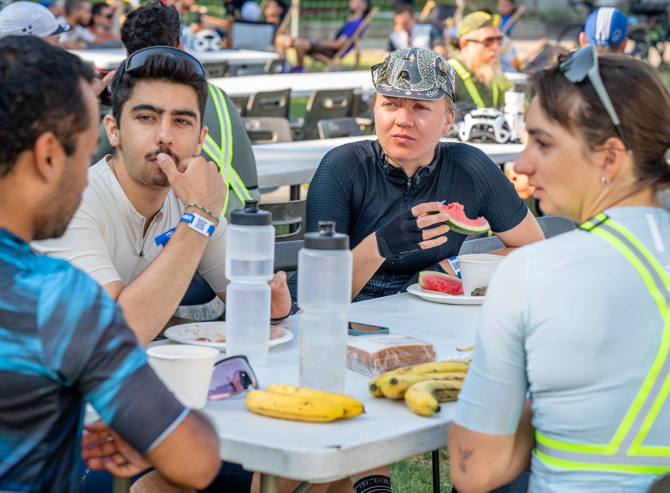 Los participantes comparten un momento de convivencia durante una comida y un suministro de fruta fresca, el símbolo de la recuperación en el ultraciclismo.
