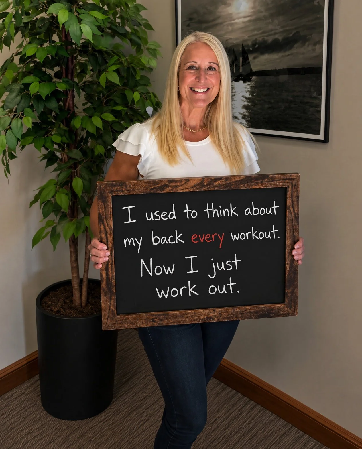 Debbie Squizzero holding a chalkboard with a testimonial for a chiropractor in Cranston, RI.