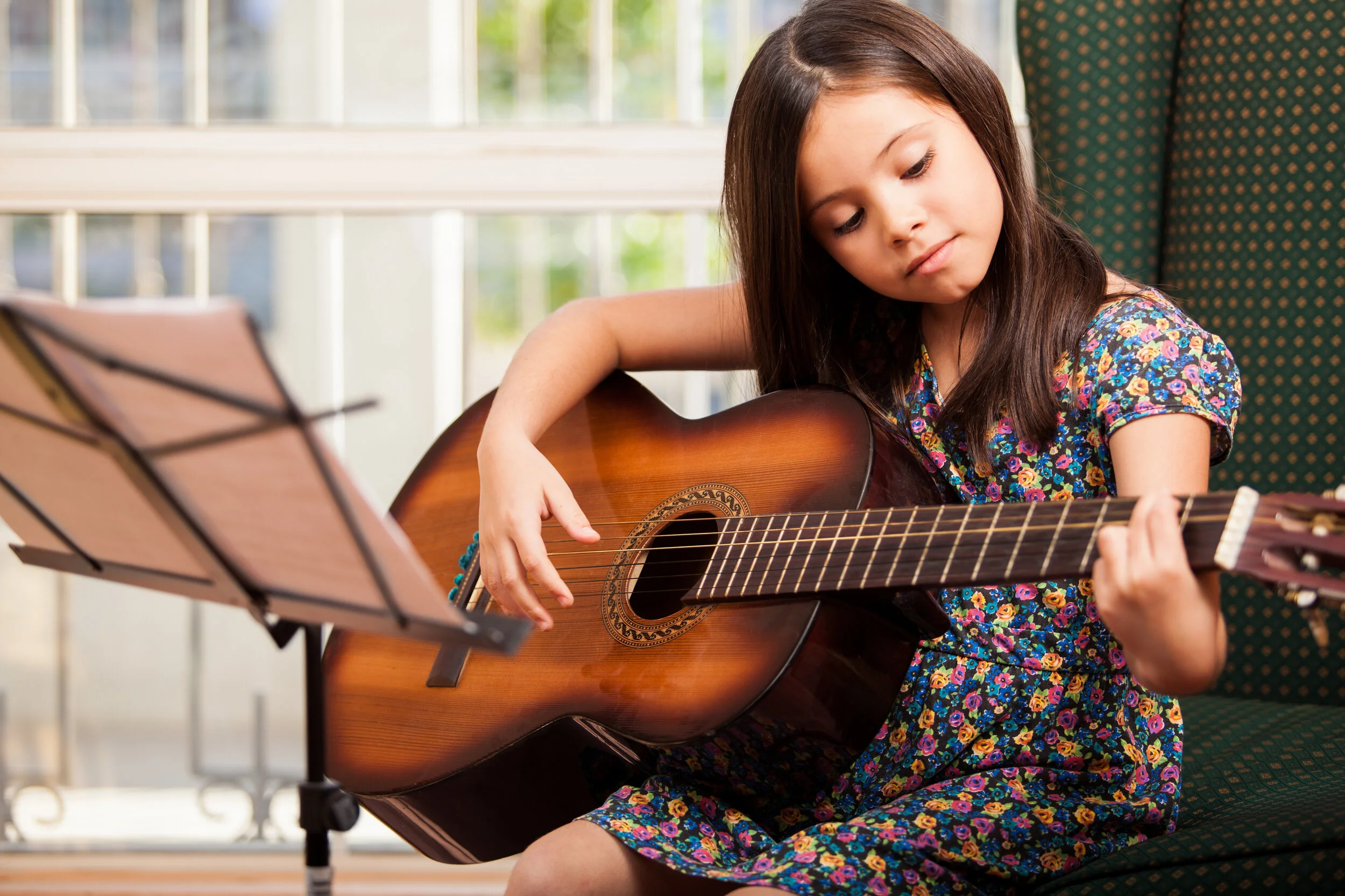 A young girl strumming a guitar