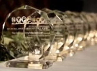 A row of transparent glass awards or trophies on a table.
