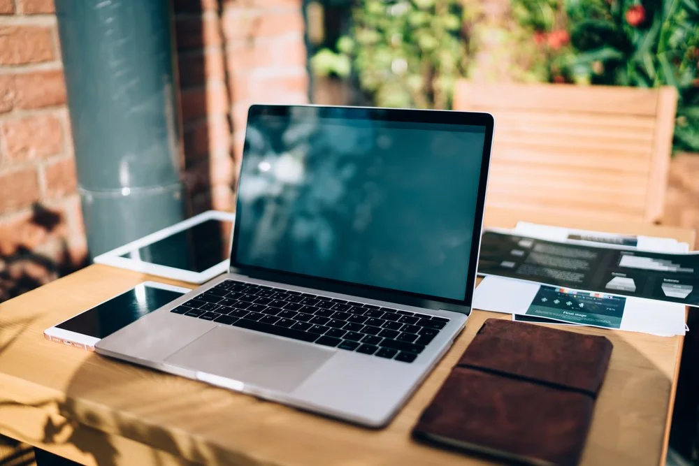 image of a laptop surrounded by plants in planters