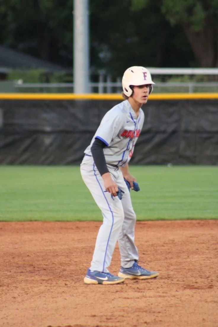 Young baseball player taking a lead off base during a club team game