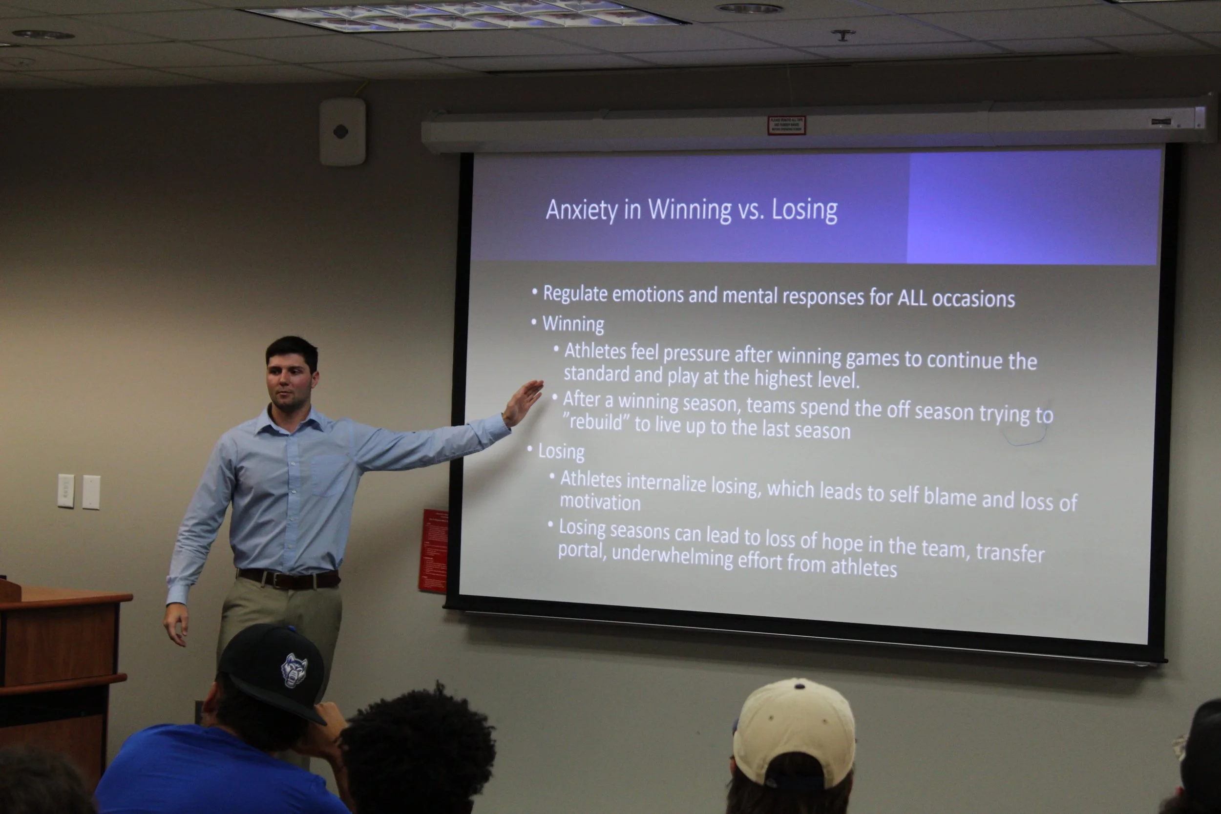 Presenting a team workshop slide on anxiety in winning versus losing