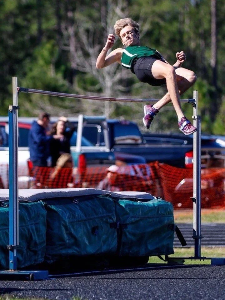 High school track athlete clearing the bar in the high jump