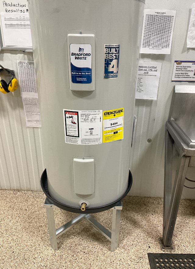 Water heater in utility room with stickers and labels.