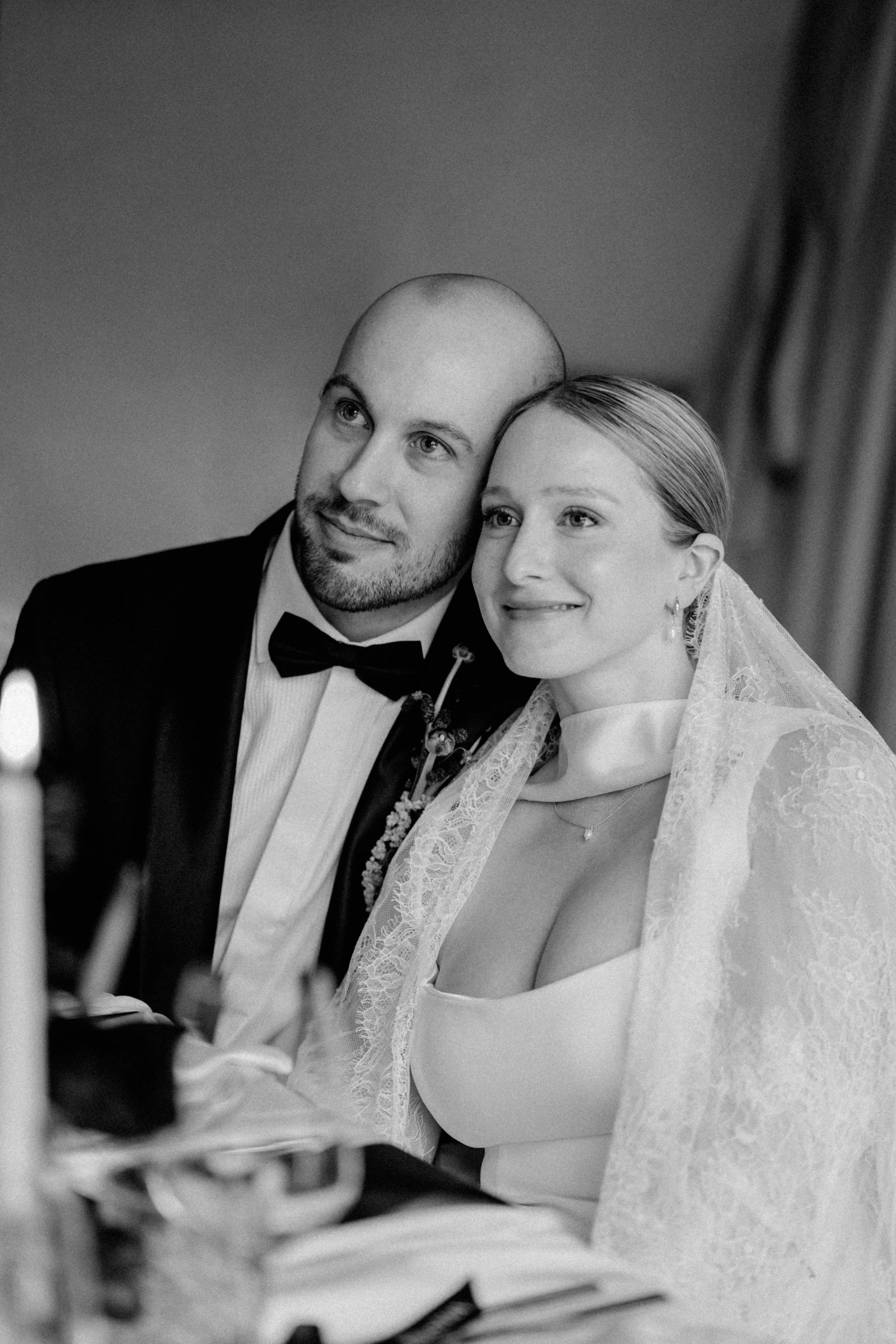 Brautpaar nebeneinander an der Hochzeitstafel