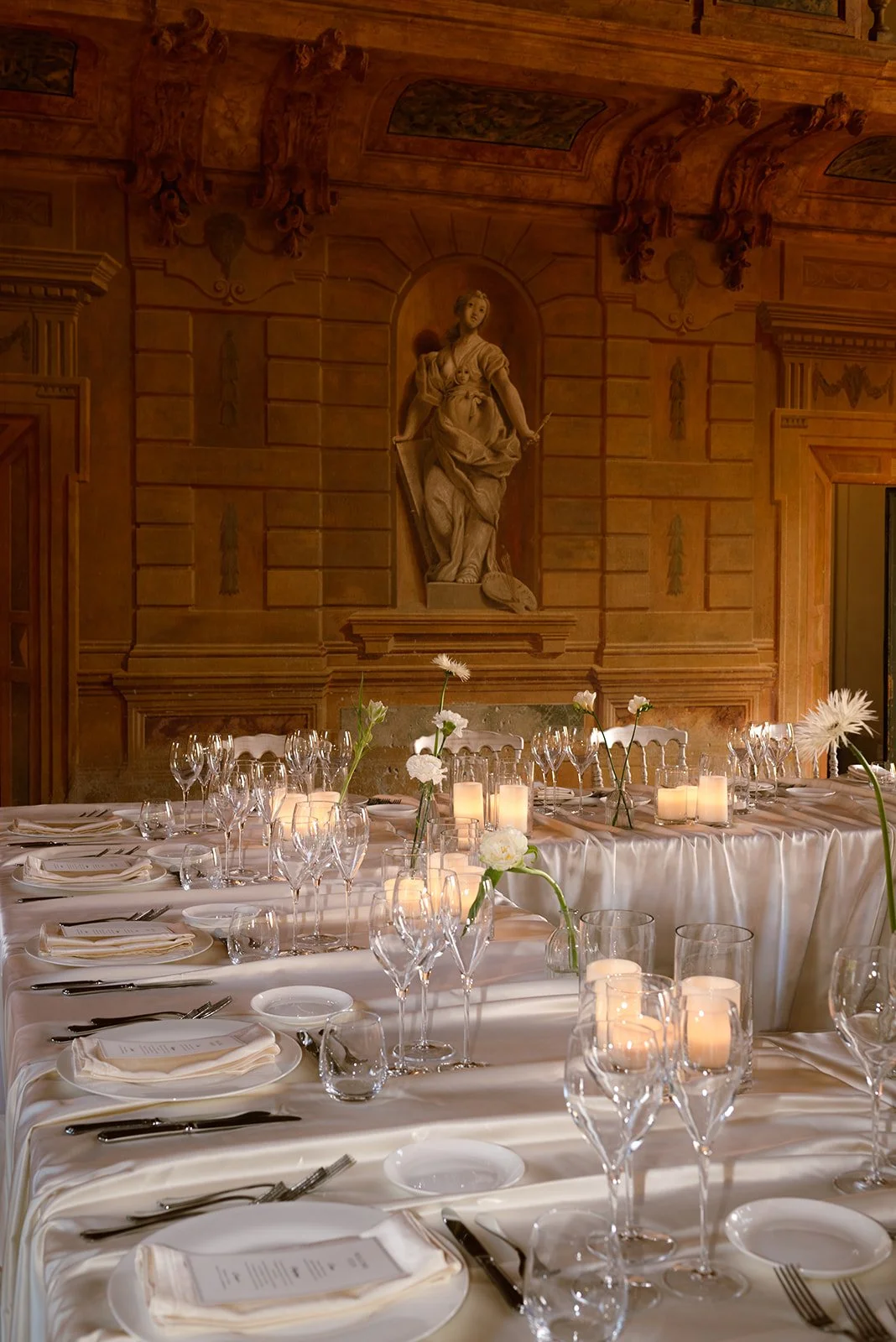 Hochzeitstafel bei Kerzenlicht im holzvertäfelten Saal der Villa