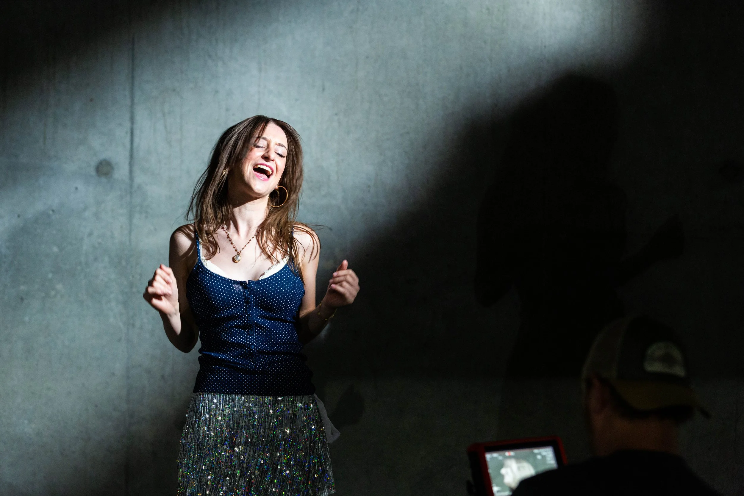 sophie briell singing on concrete background during a music video shoot in sandy utah