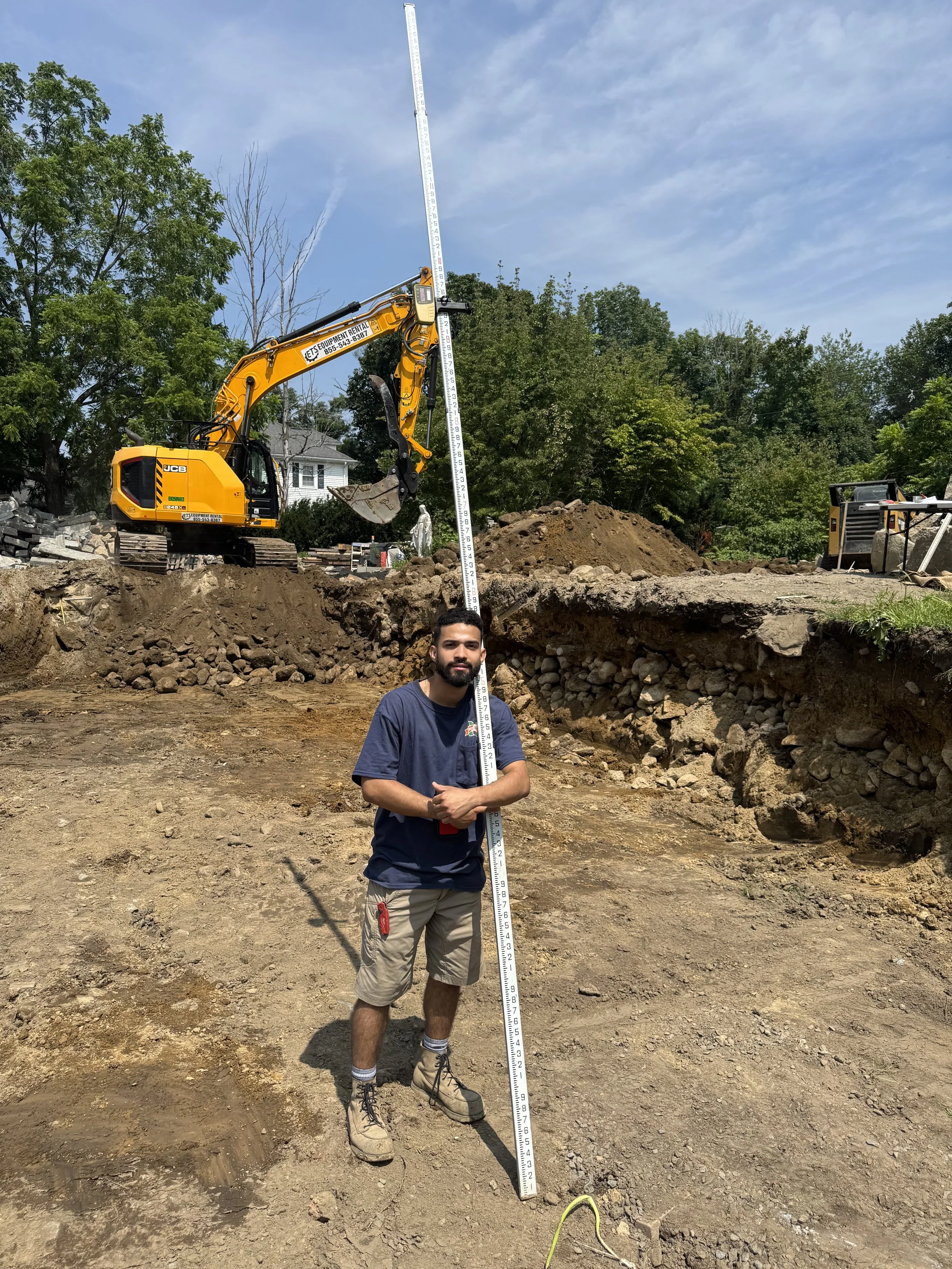 Construction scene with Kubota SCL 1000 skid steer loader moving dirt next to a building under renovation.