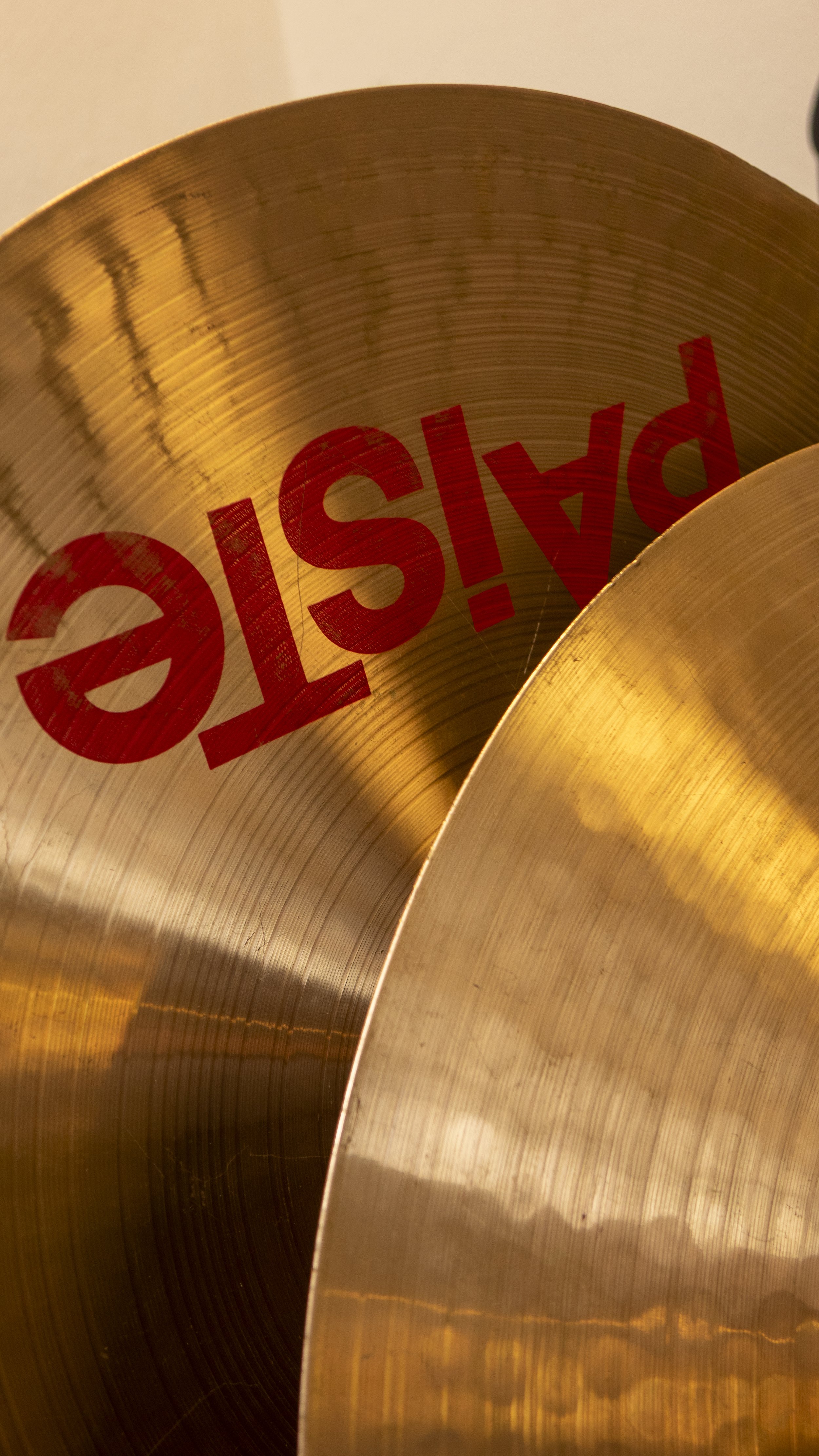 Nahaufnahme von Becken mit Markenlogo in roter Schrift. Die Oberfläche ist glänzend und reflektiert Licht.