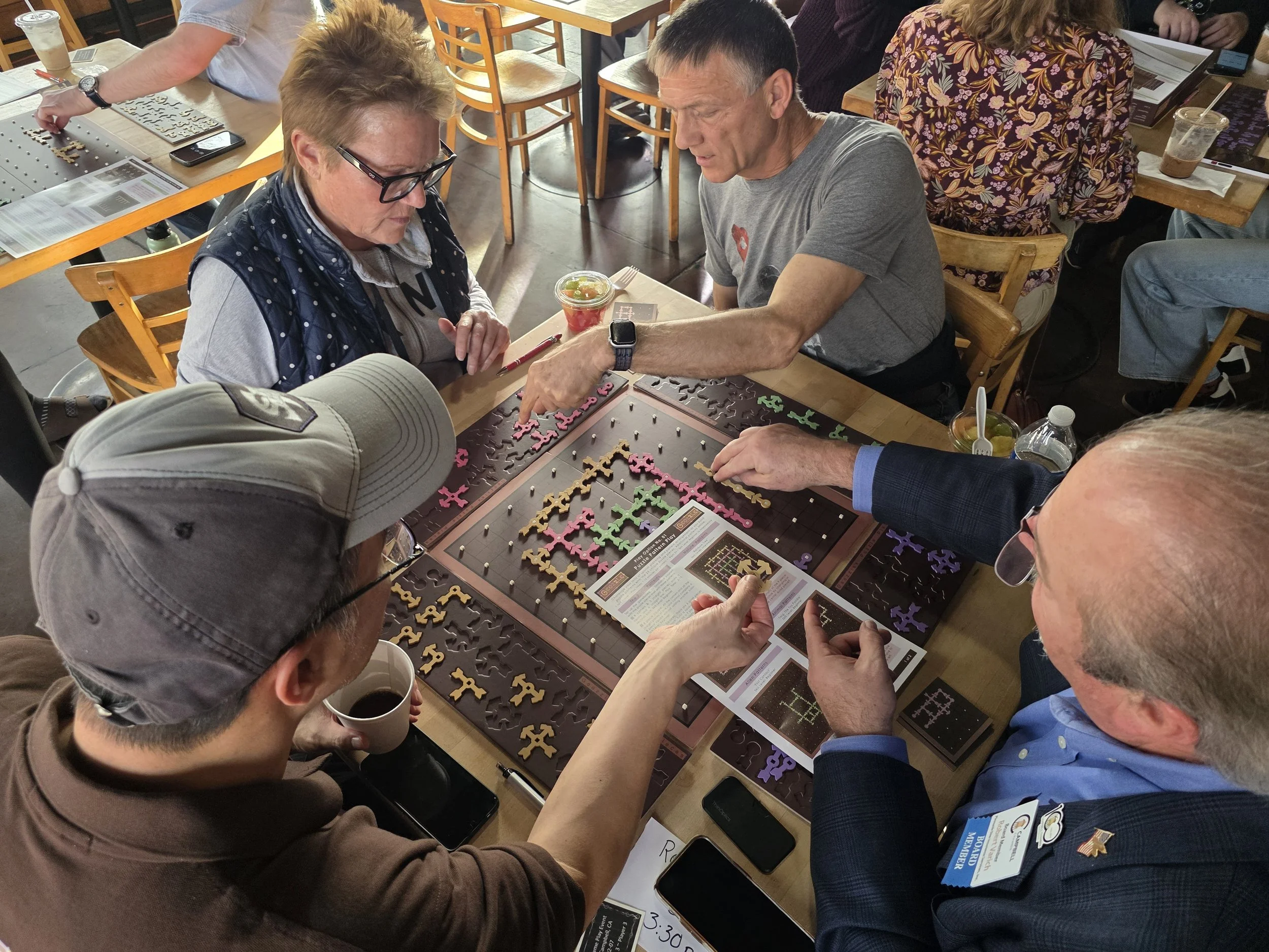 People gathered around a table playing a puzzle game called 'Puzzle Palooza.'