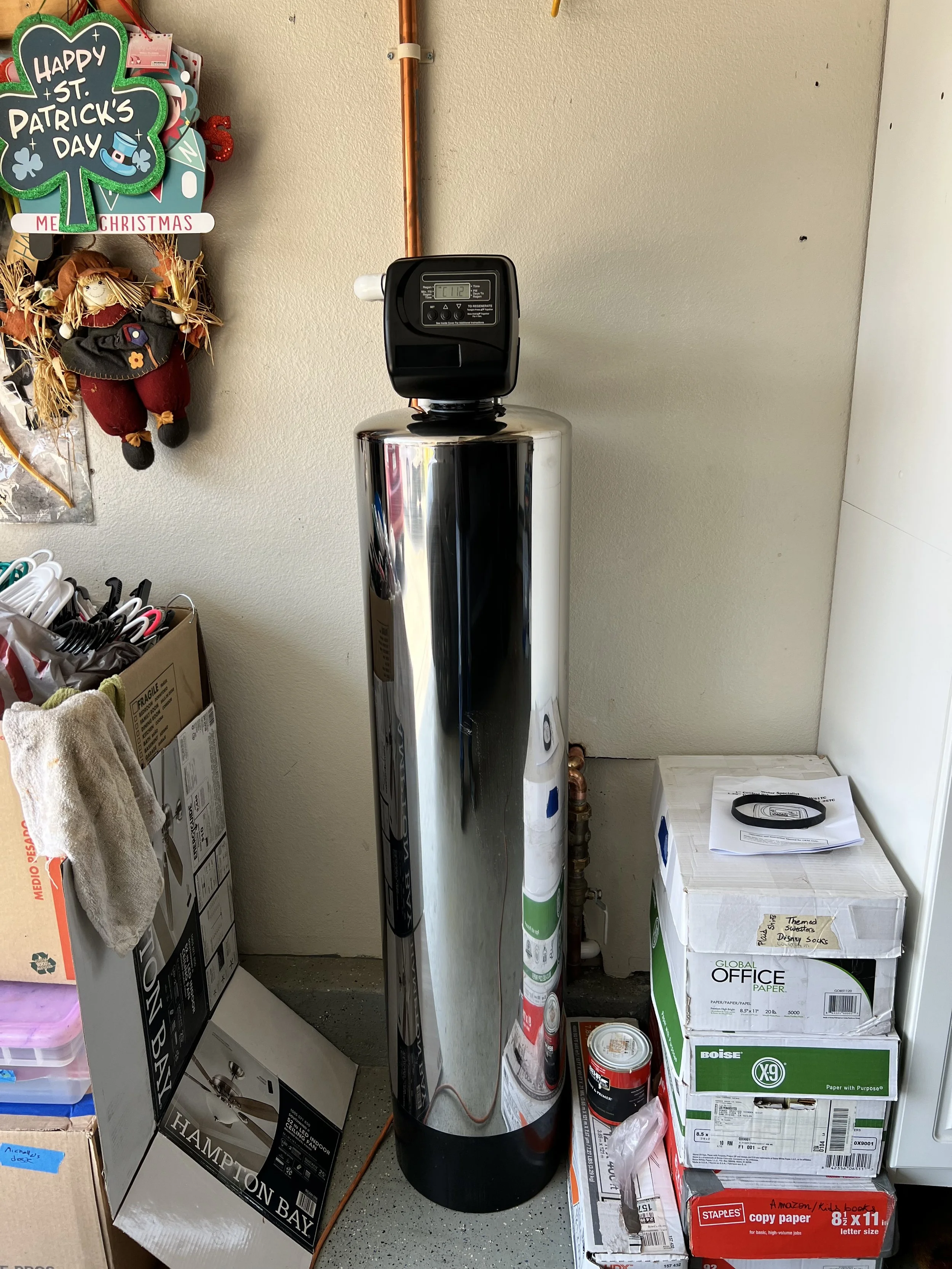 Whole house water filtration system installed in Carlsbad, CA garage, connected to main water line for clean, chemical-free water.