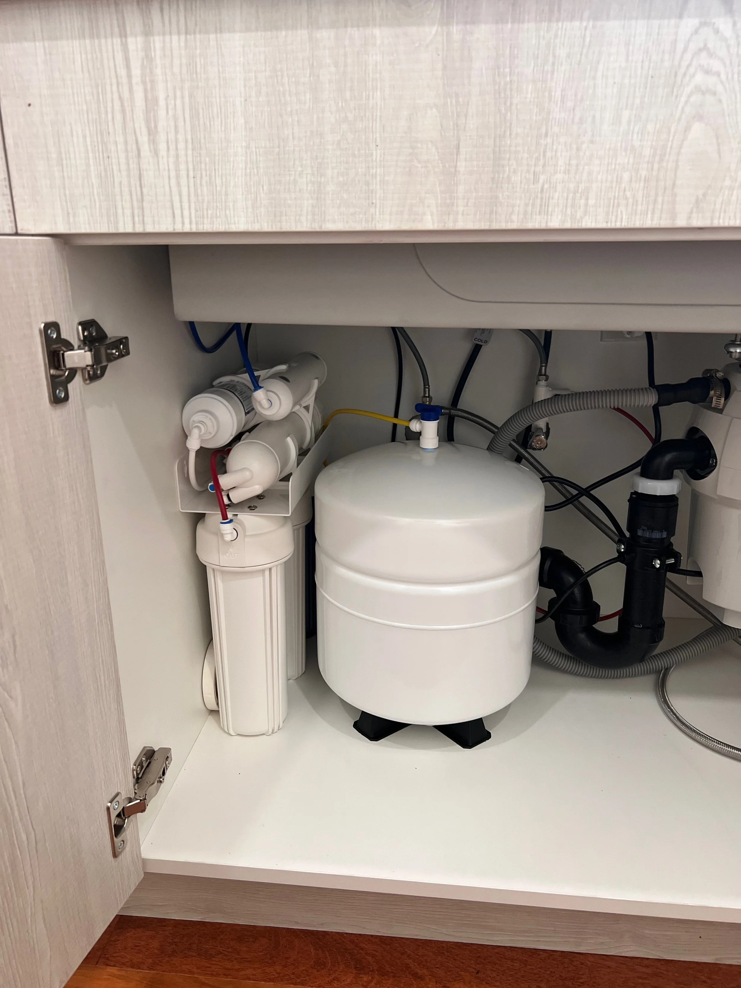 Reverse osmosis water filtration system professionally installed under a kitchen sink in San Diego by Filtercon Technologies.