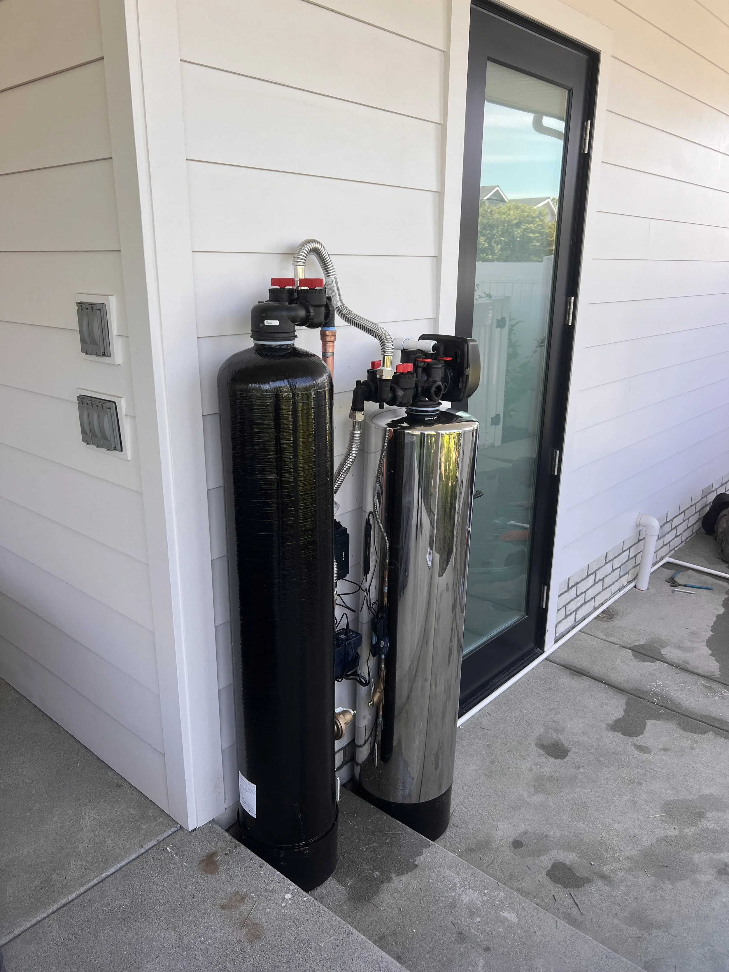 Whole house water filtration and conditioning system installed outside a San Diego home