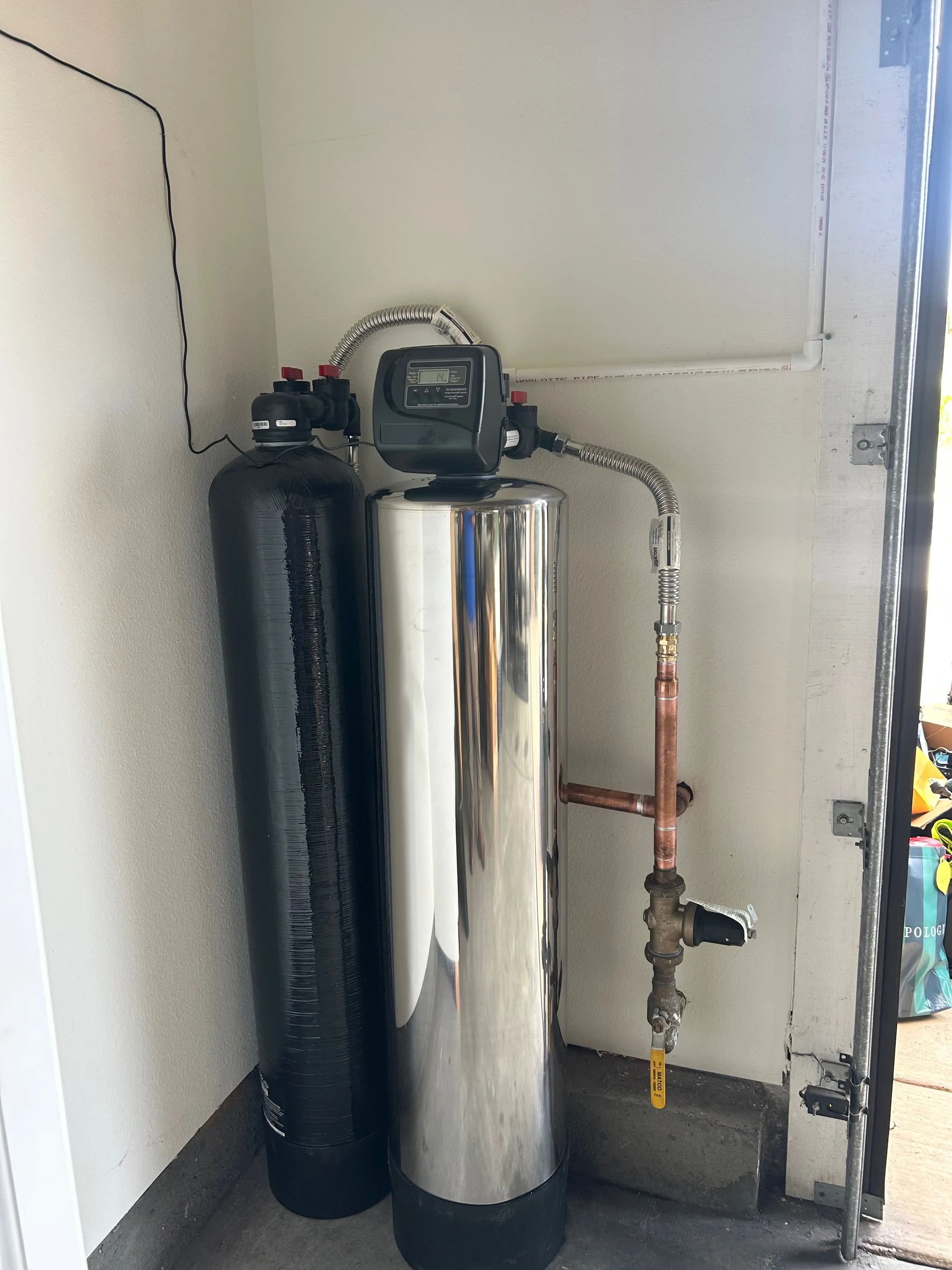 Whole house water filtration system installed in a Carlsbad, CA garage, connected to the home's main water line.