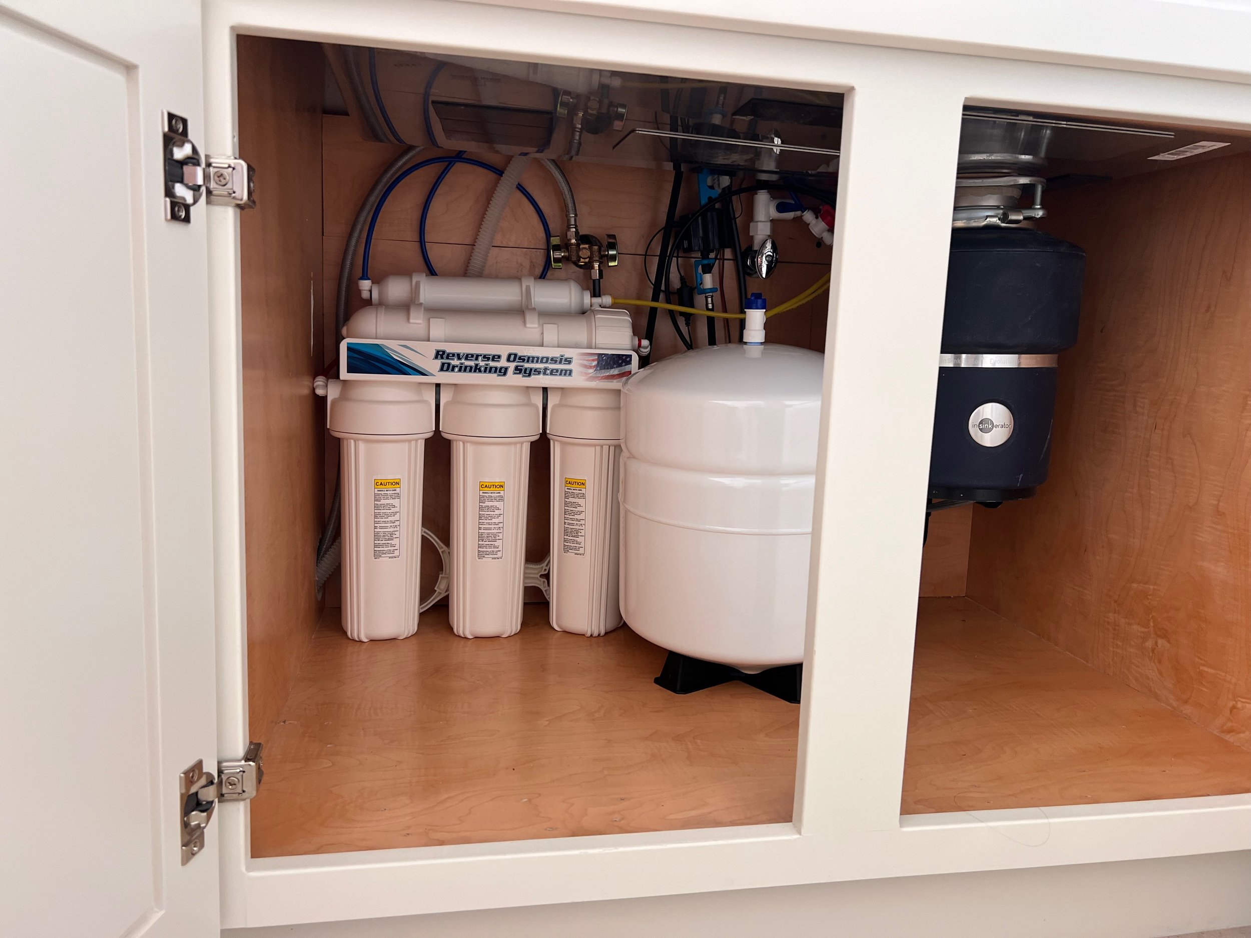 Alkalizer reverse osmosis system installed inside a San Diego kitchen cabinet for clean drinking water.