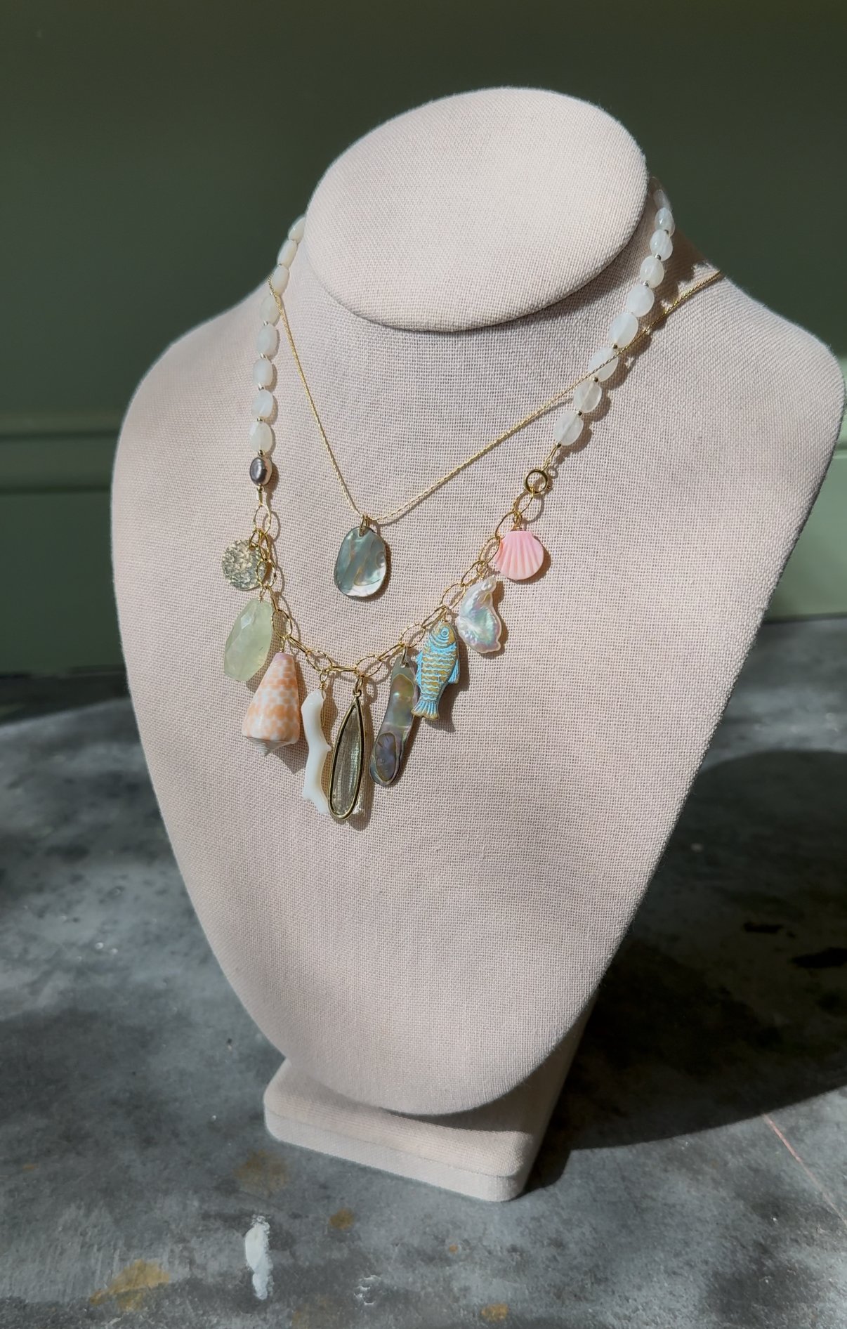 Jewelry display with beaded necklace and seashell charms