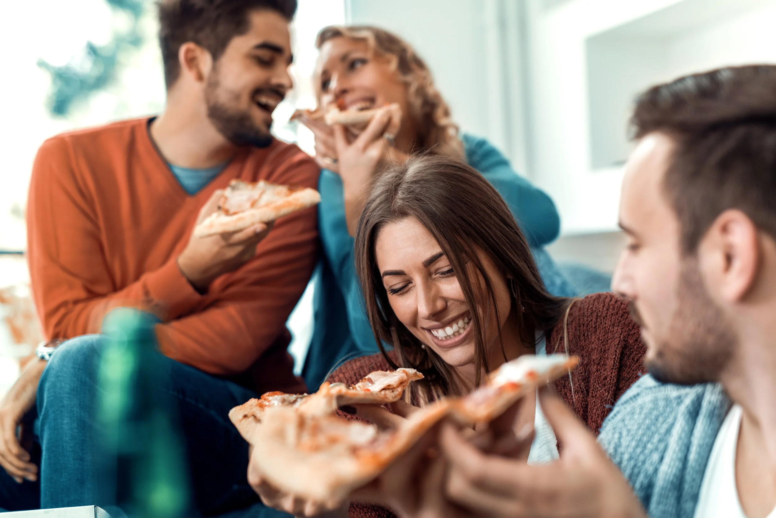 Group of friends enjoying pizza in a 1 bedroom apartment in LA, showing vibrant and social apartment living.