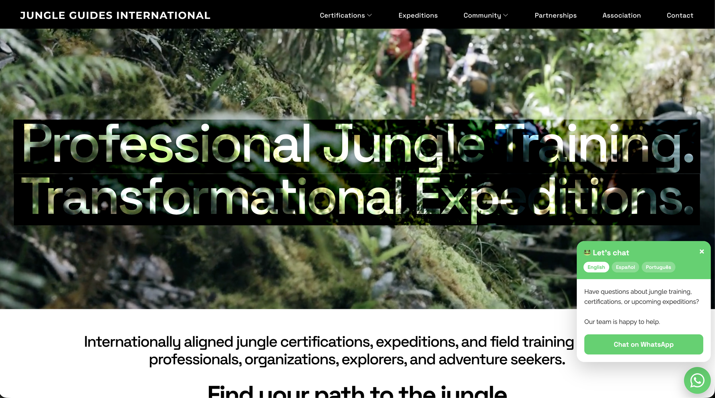 A website homepage for Jungle Guides International showing a blurred image of hikers in a jungle, with overlay text that reads 'Professional Jungle Training. Transformational Expeditions.' The top menu includes options for certifications, expeditions, community, partnerships, association, and contact. There is a live chat box in the bottom right corner offering language options and a WhatsApp chat button.