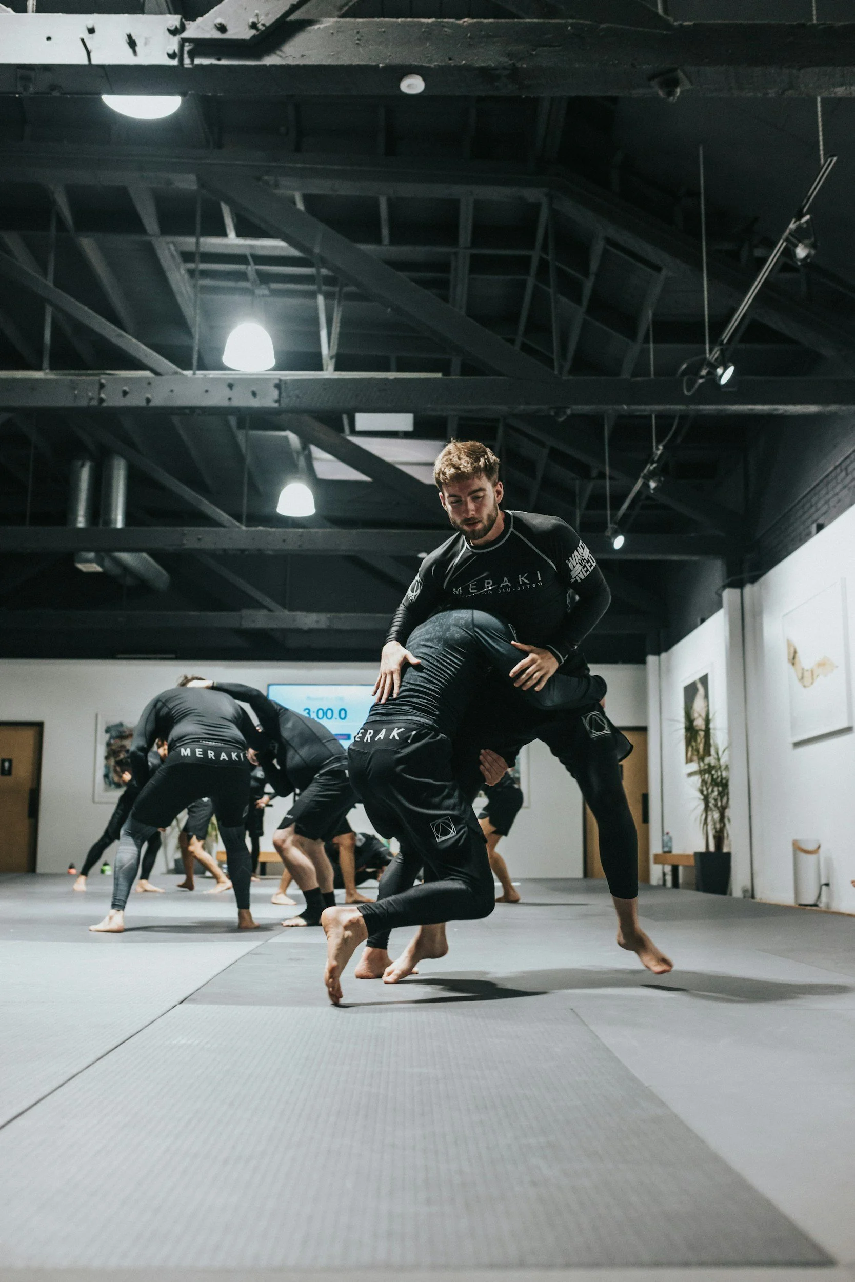 Menschen trainieren in einem Dojo, während sie Brazilian Jiu-Jitsu üben.