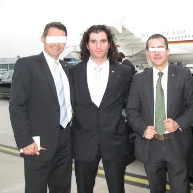 Drei Männer in Anzügen stehen vor einem Flugzeug.