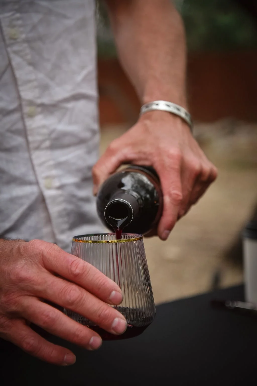 A bartender pours wine into a glass at a small Arizona wedding.
