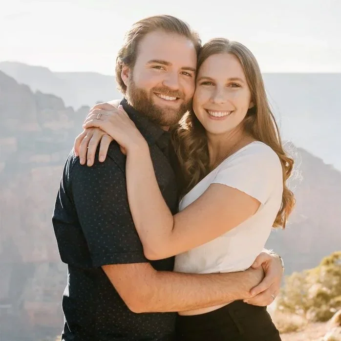 A man and woman share a hug at the Grand Canyon.