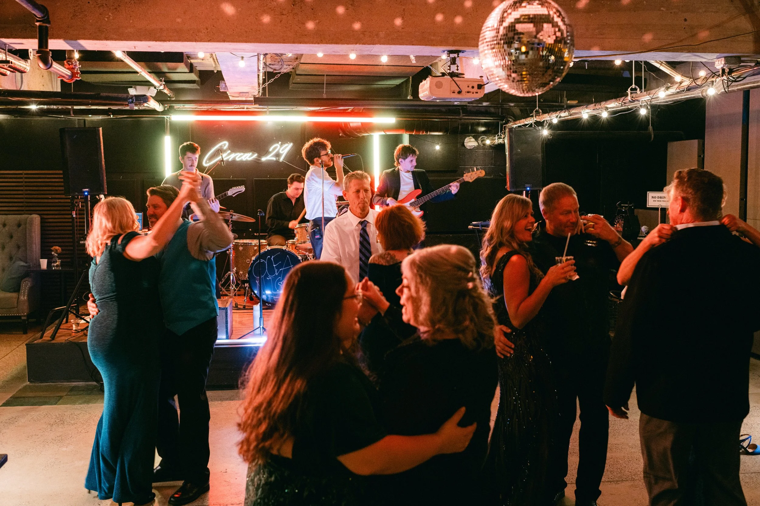 Group of party guests smiling while seated around a dinner table