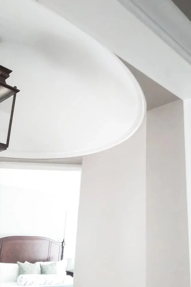 Finished domed plastered ceiling with circular trim detail at wall and ceiling.